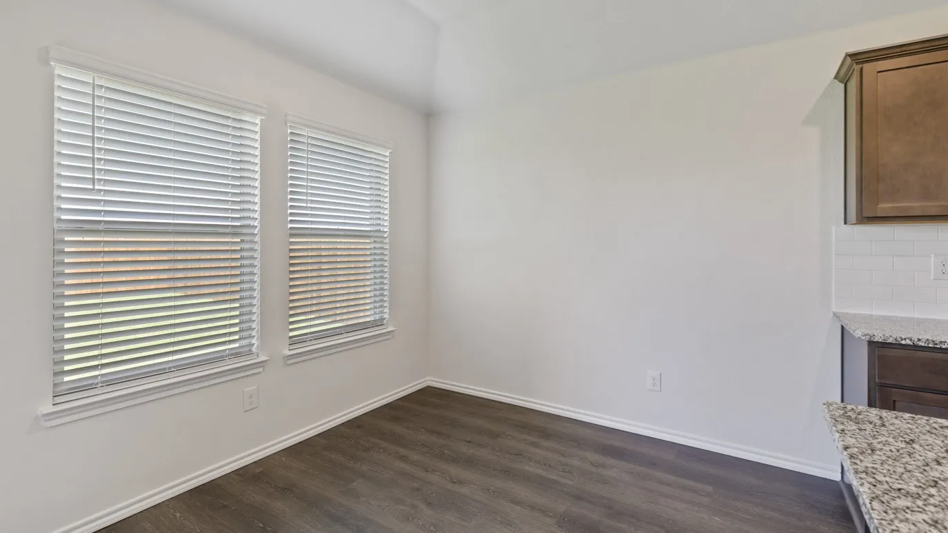 Dual windows with blinds, wood-finish flooring, white subway tile backsplash, and granite countertops