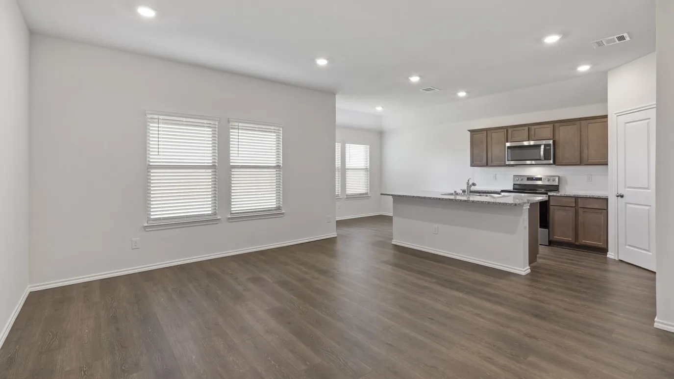 Open-concept living space featuring wood-finish flooring, recessed lighting, and ample natural light from multiple windows