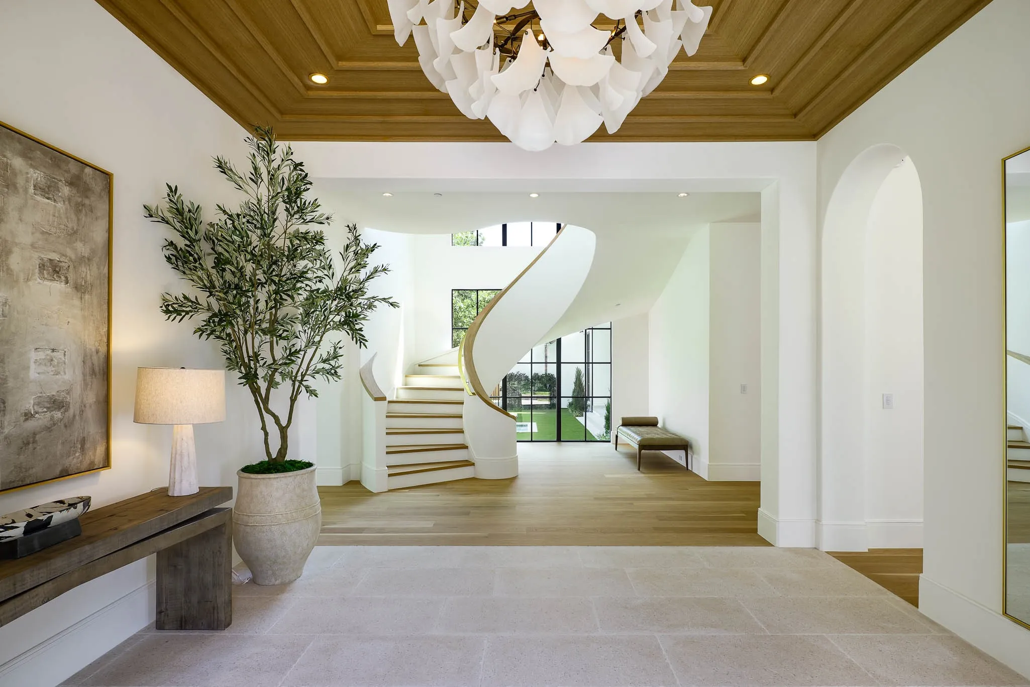 Gracious formal entry with floating staircase, custom ceiling design, and Bella Figura Lyra chandelier