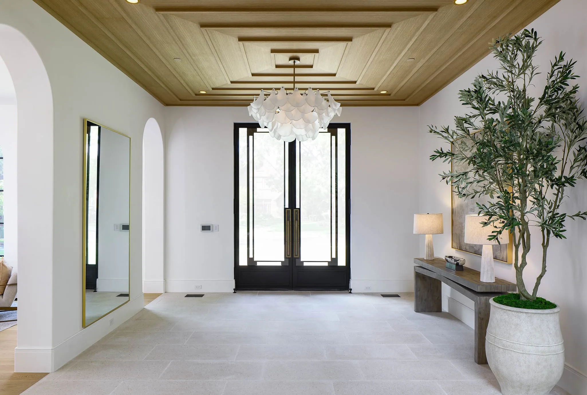 Gracious formal entry with custom steel and glass front doors and limestone floors