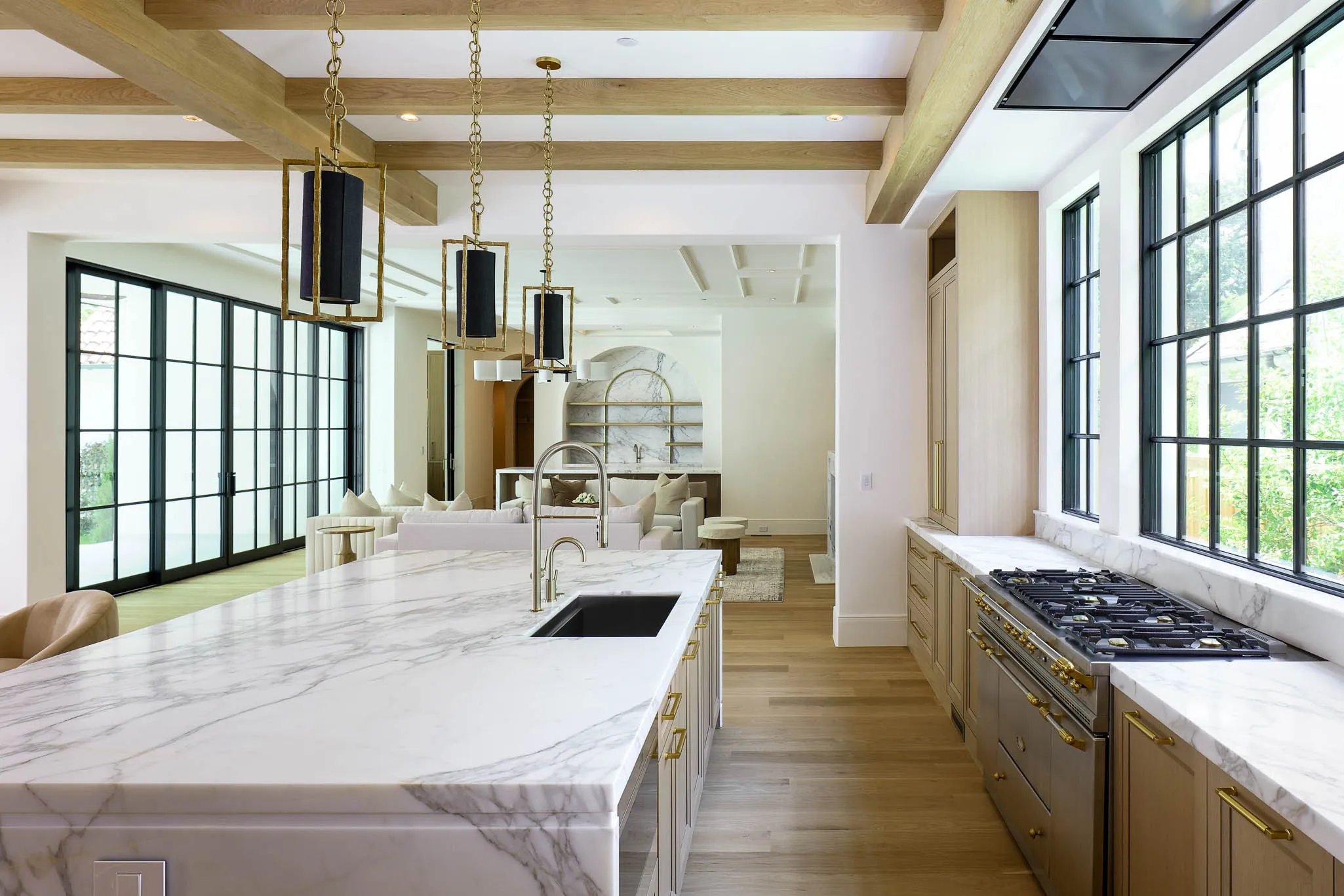 View of Kitchen island with marble slab countertops, 60in Lacanche range into Family Room
