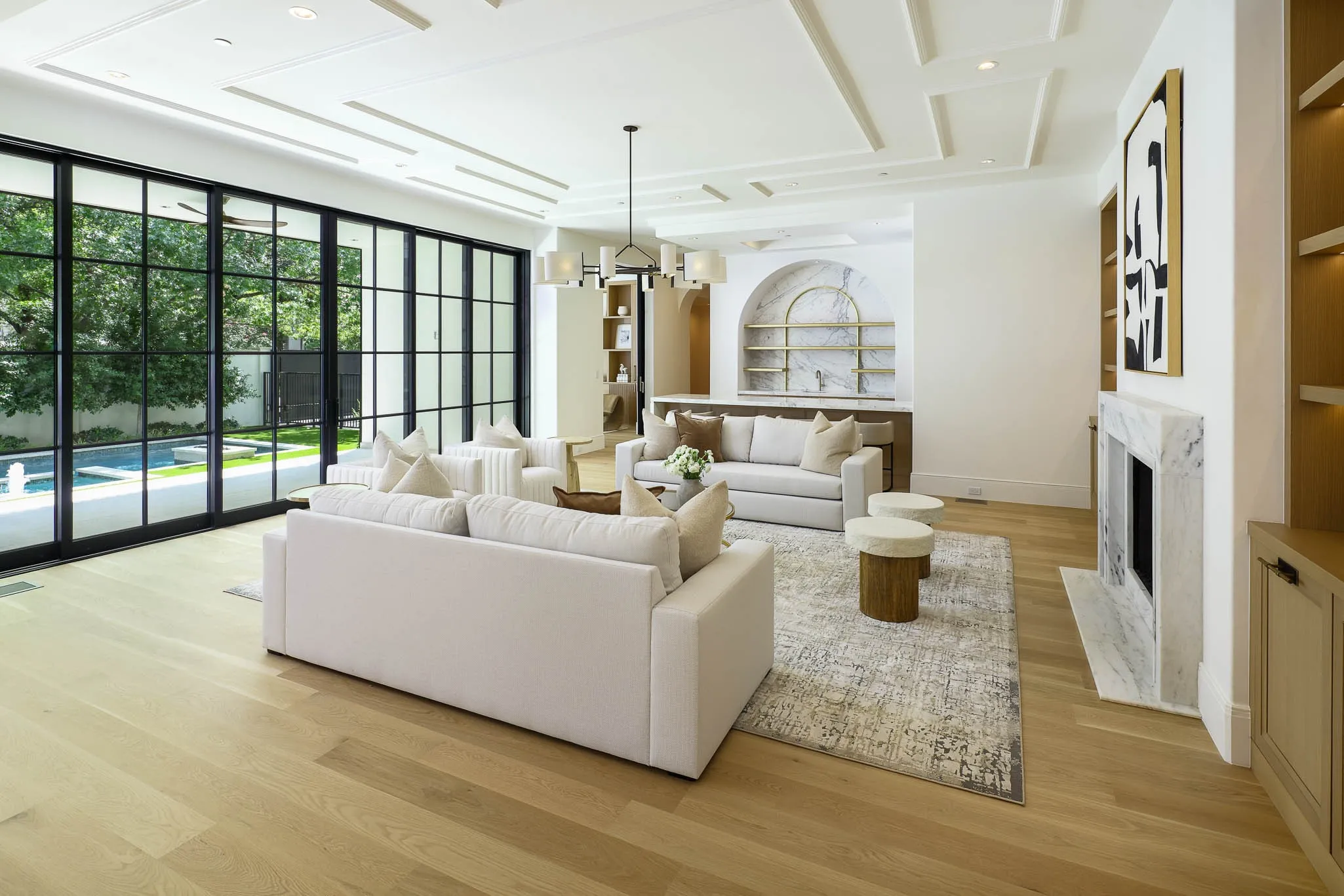 Family Room with gas fireplace and custom built-ins open to Formal Bar, Wine Room, and Kitchen