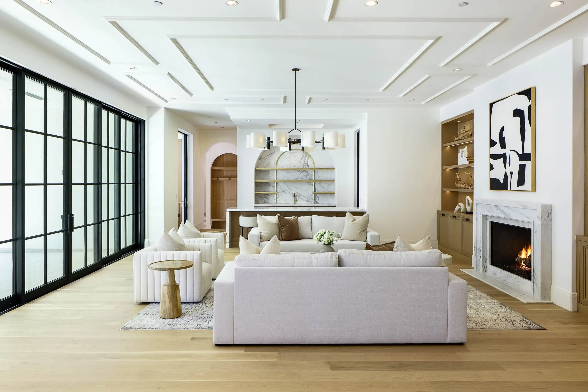 Family Room with gas fireplace and custom built-ins open to Formal Bar, Wine Room, and Kitchen
