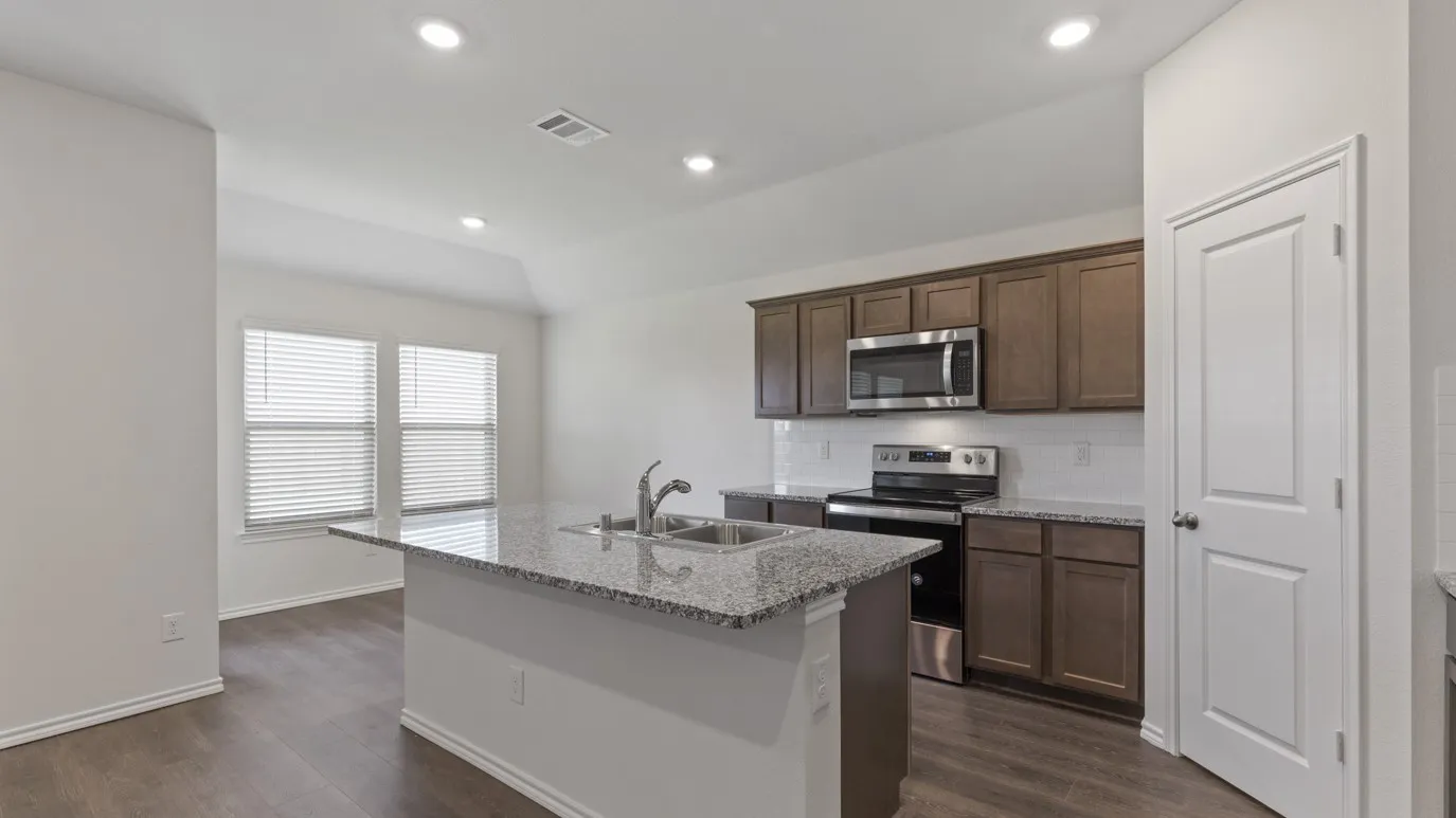 Kitchen island with granite countertop, stainless steel double basin sink, and integrated dishwasher