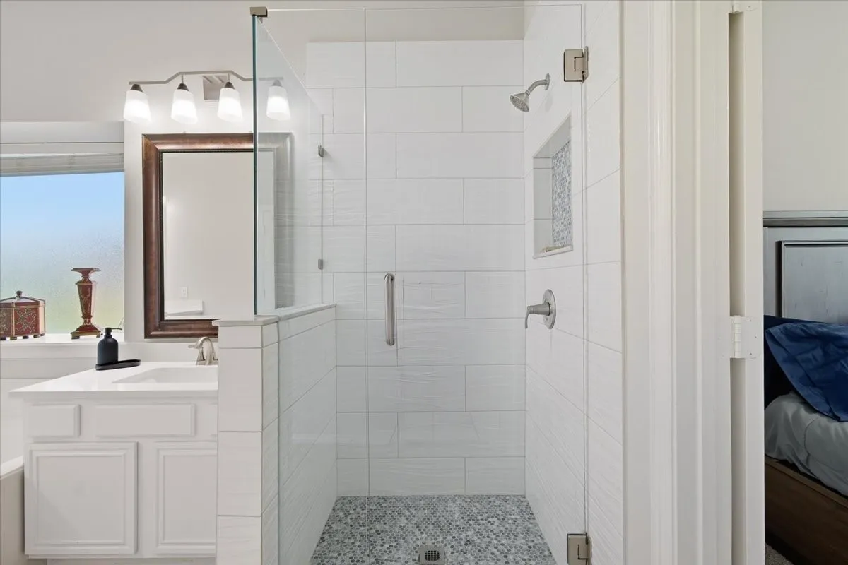 White shaker vanity with a single basin sink and a stone countertop