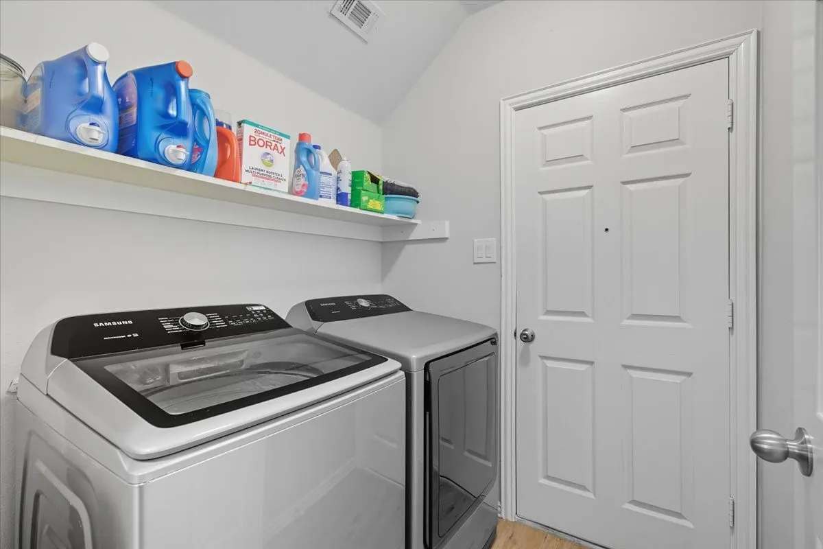 Laundry area with wall-mounted shelving and light-toned flooring
