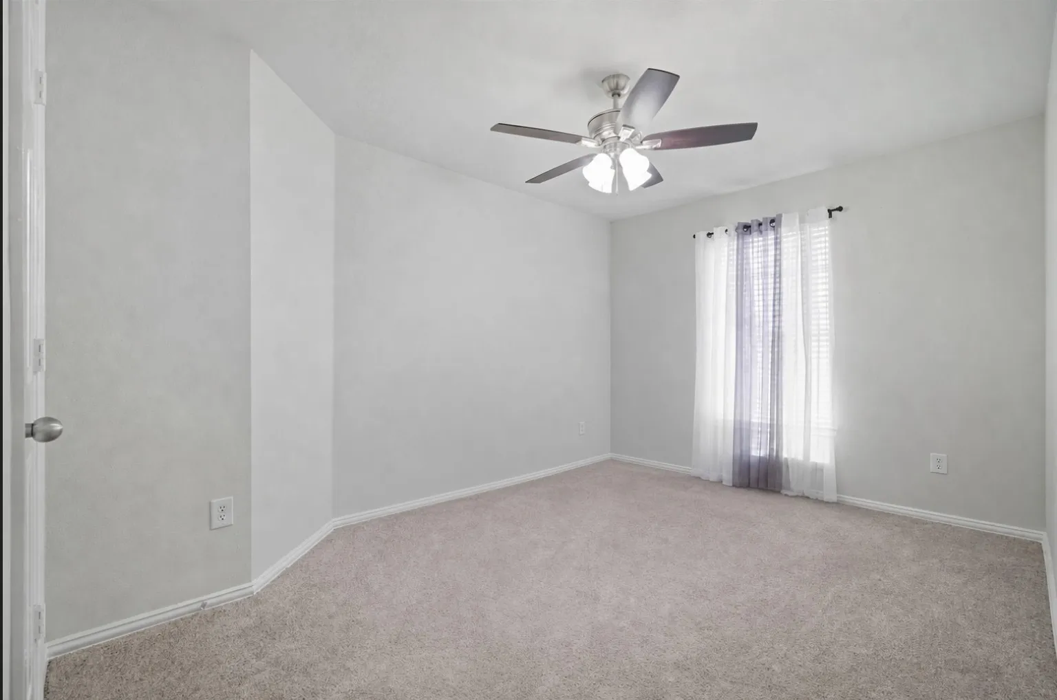 Neutral wall color, wall-to-wall carpeting, ceiling fan with light fixture, window with blinds