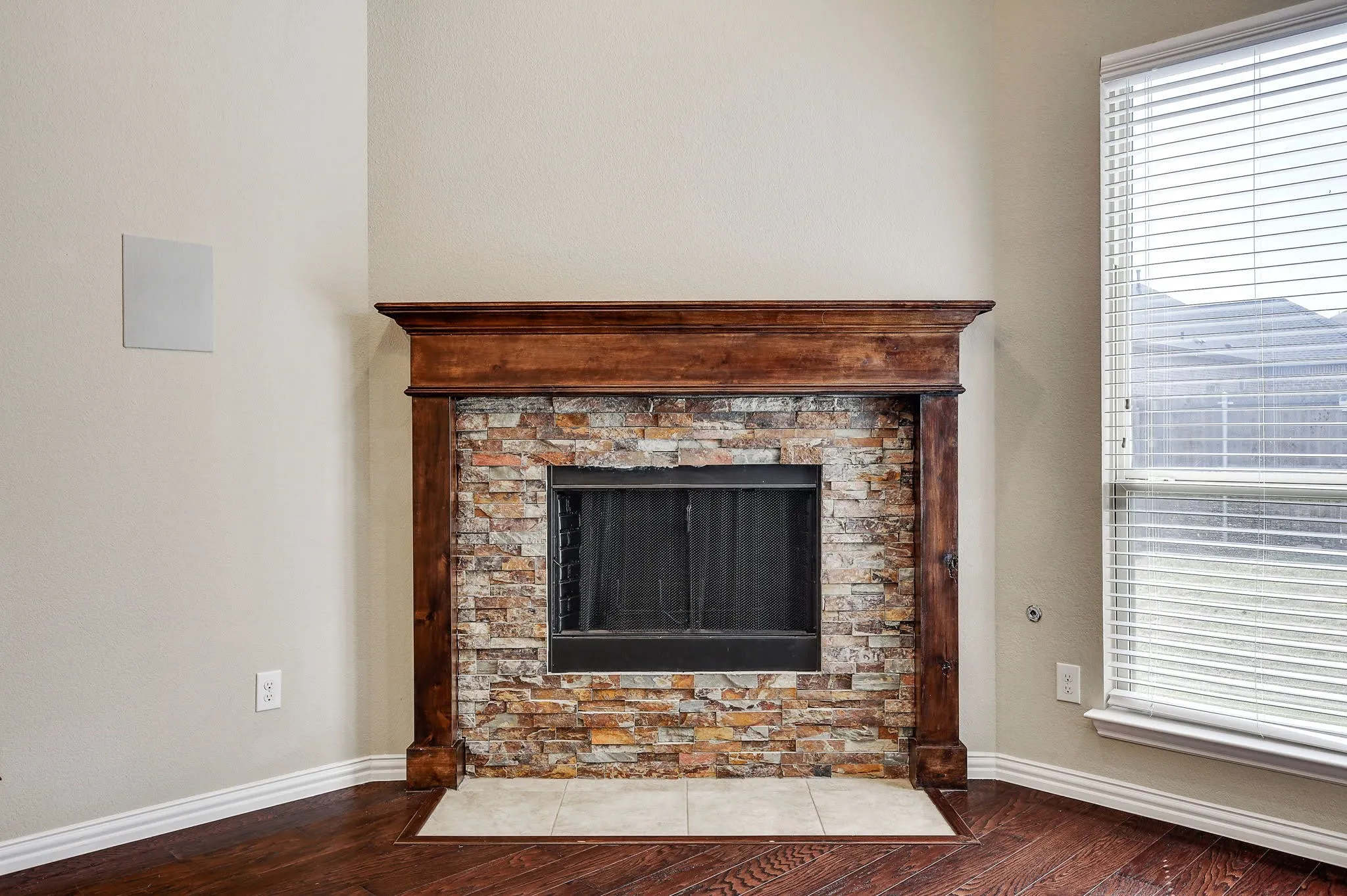 Fireplace featuring a stone facade and a substantial wood mantel