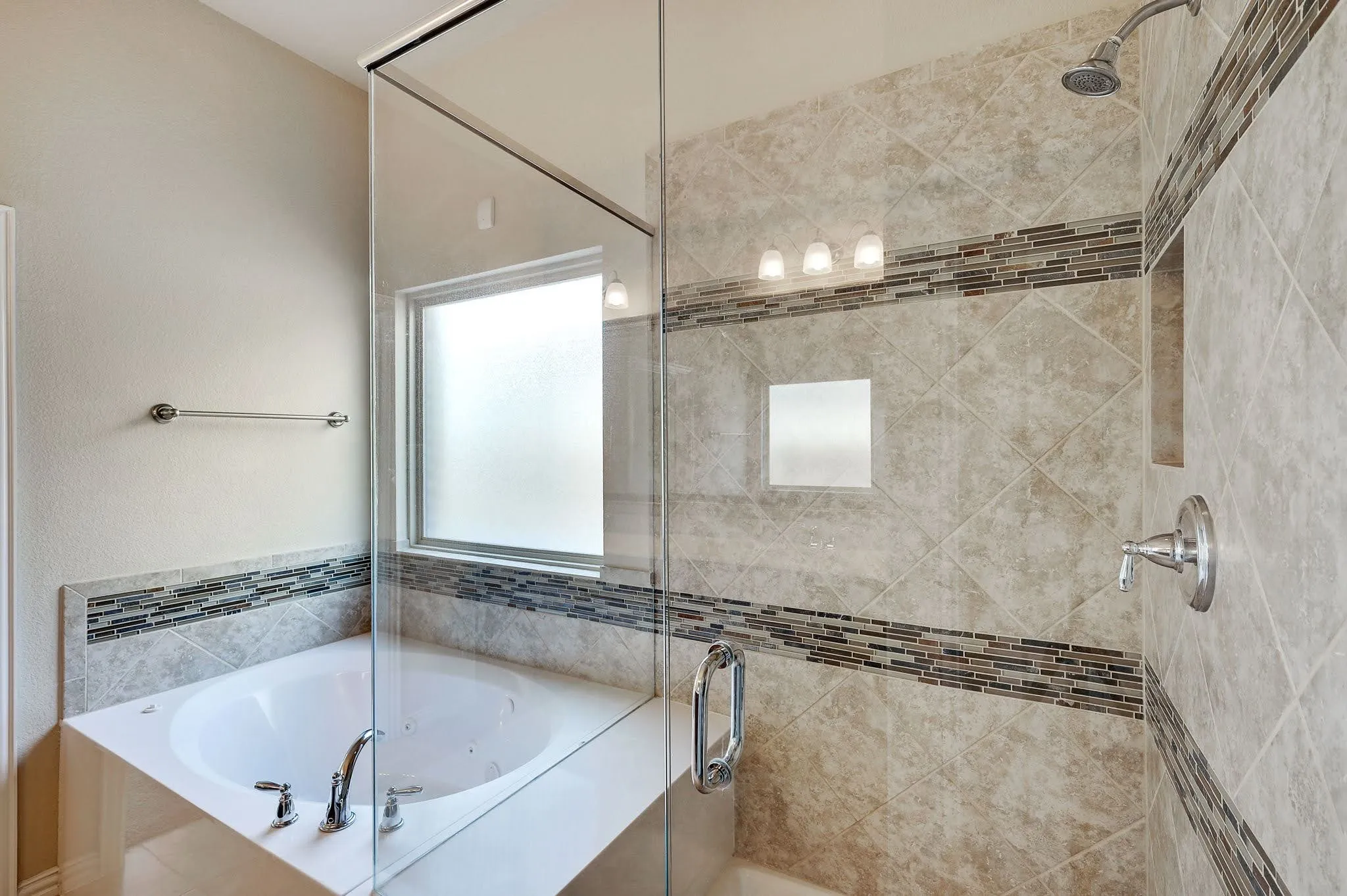 Glass-enclosed shower with a built-in niche and a corner soaking tub with a privacy window