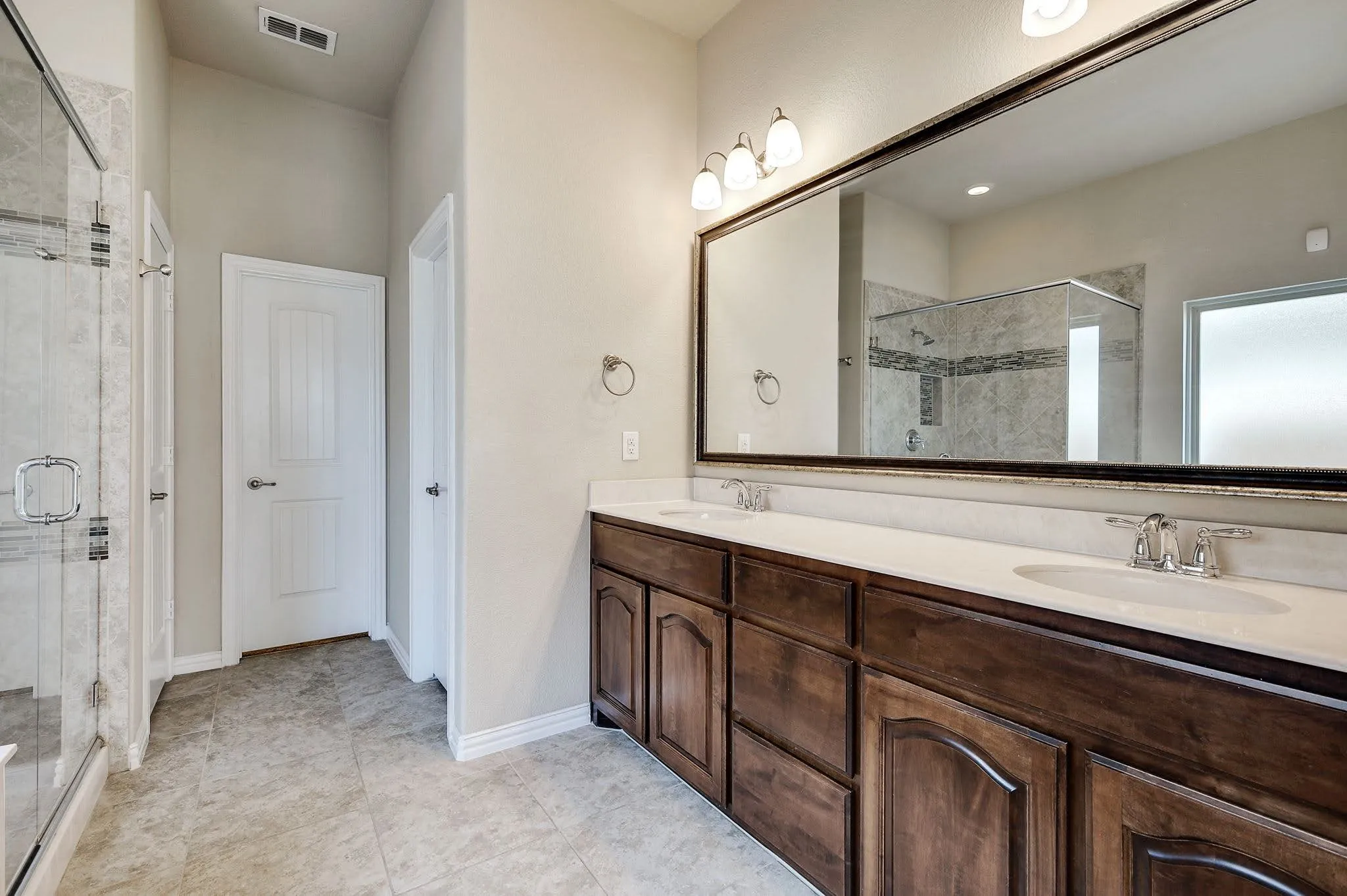 Dual vanity with wood-finish cabinetry and light countertops