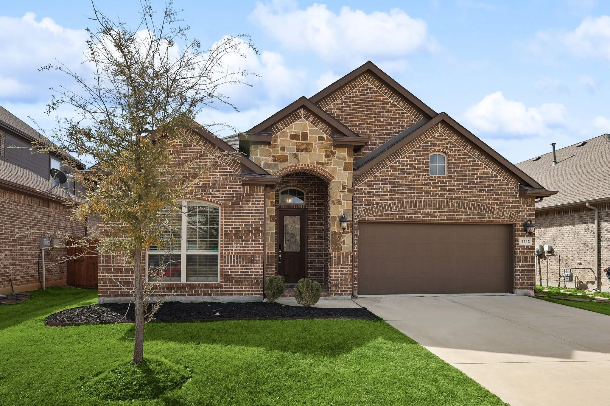 Brick exterior with stone accents and arched entry