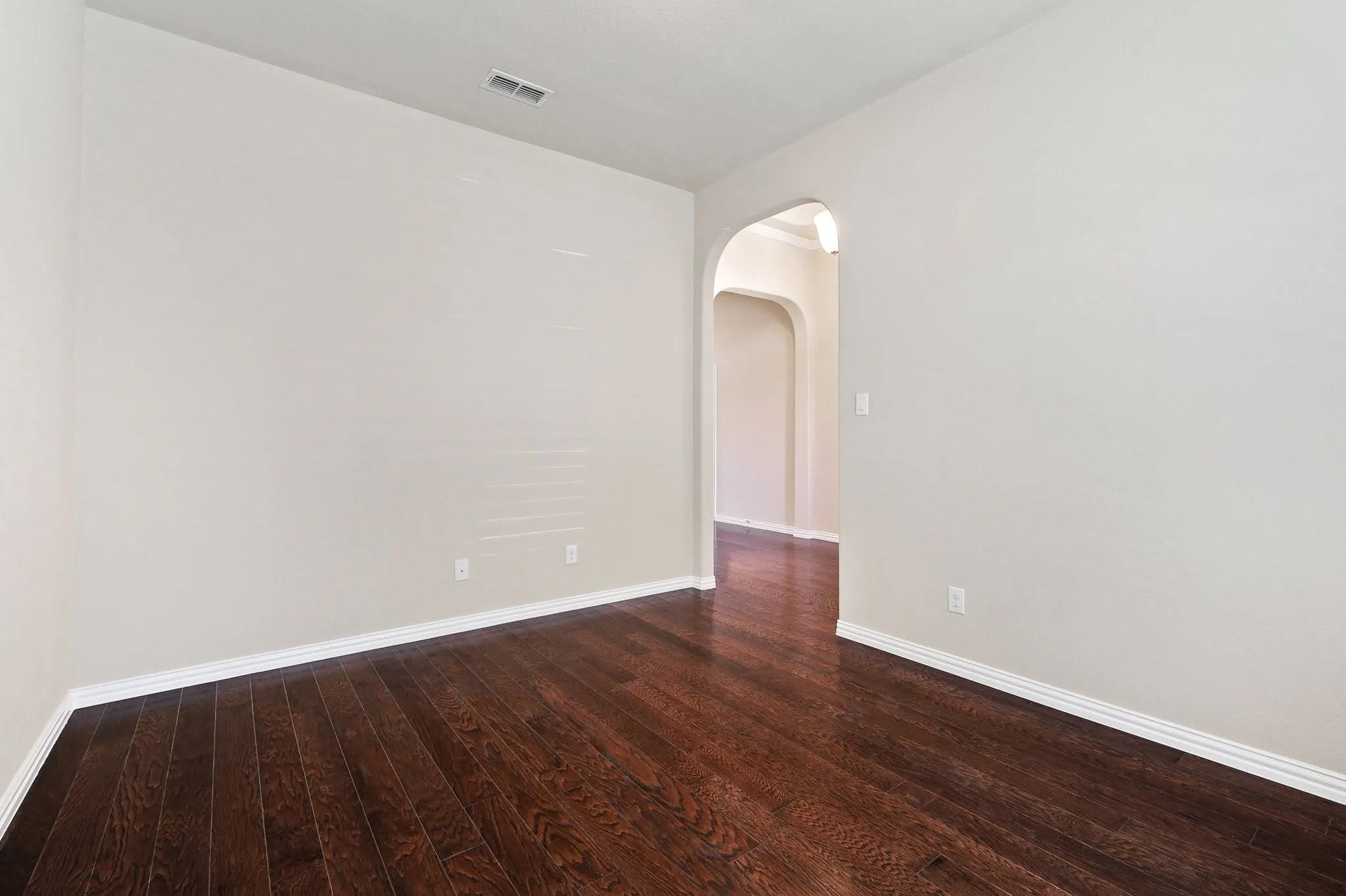 Dark wood-finish flooring with white baseboards