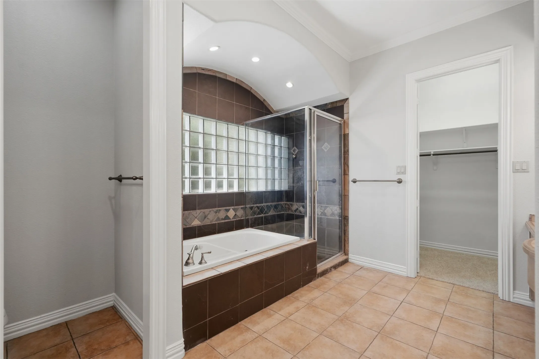 Primary bath has lots of natural light while maintaining privacy as well as a tub and shower