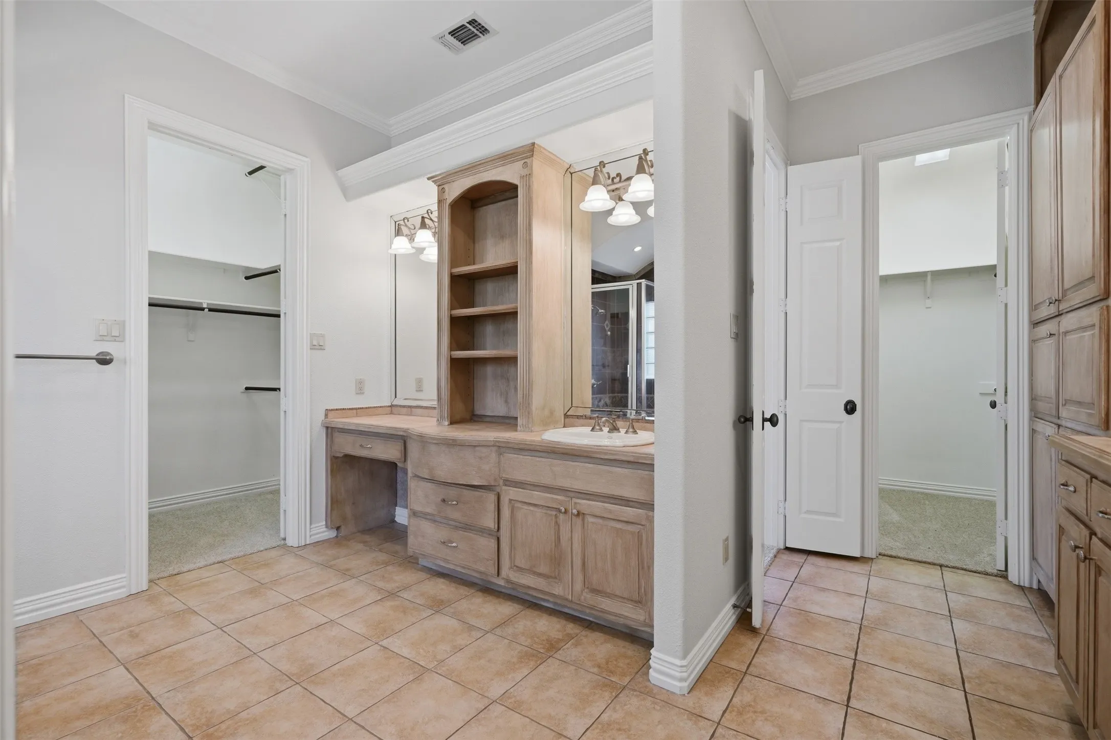 Primary bath features separate vanities & closets