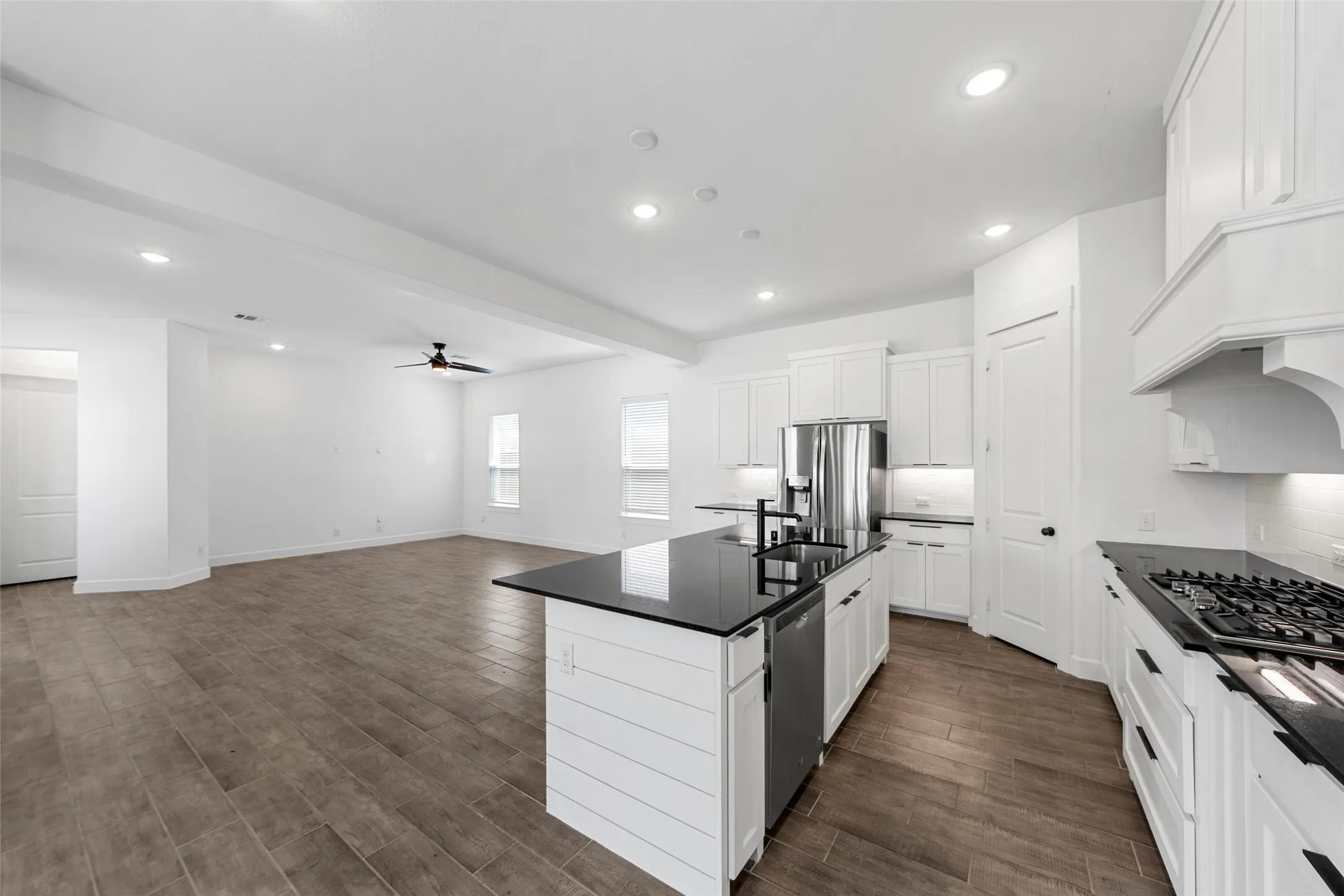Open-concept layout featuring wood-finish flooring, recessed lighting, and a ceiling fan