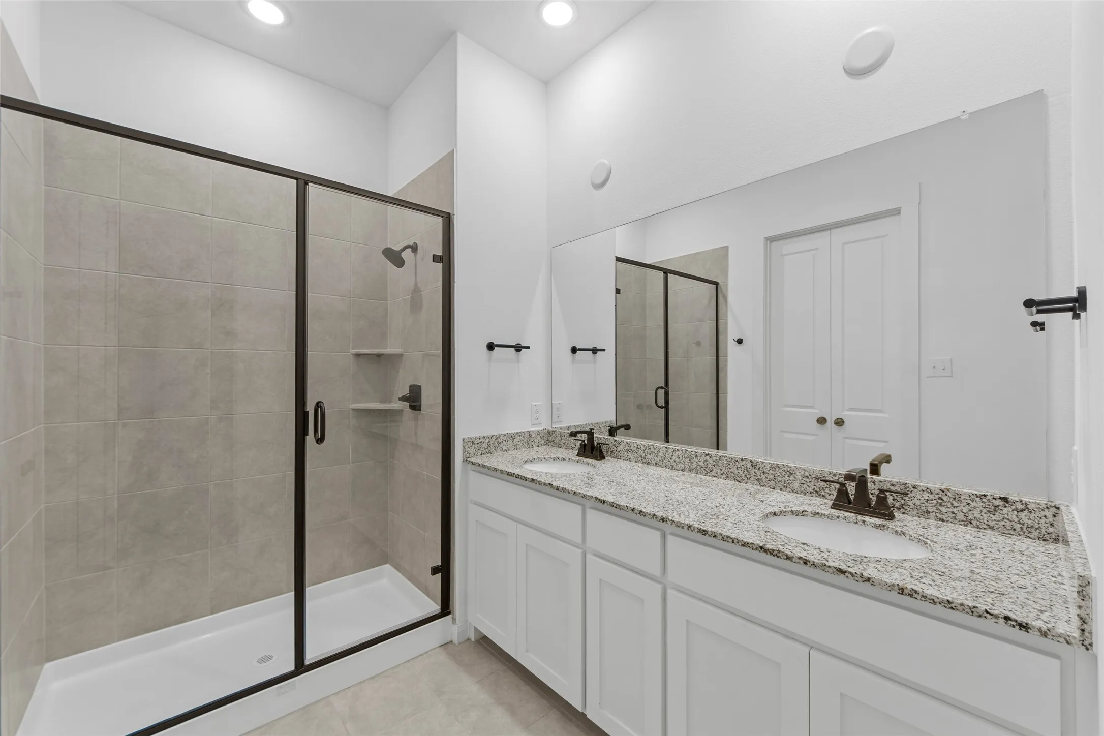 Dual vanity with granite countertops, integrated sinks, and bronze-finish faucets