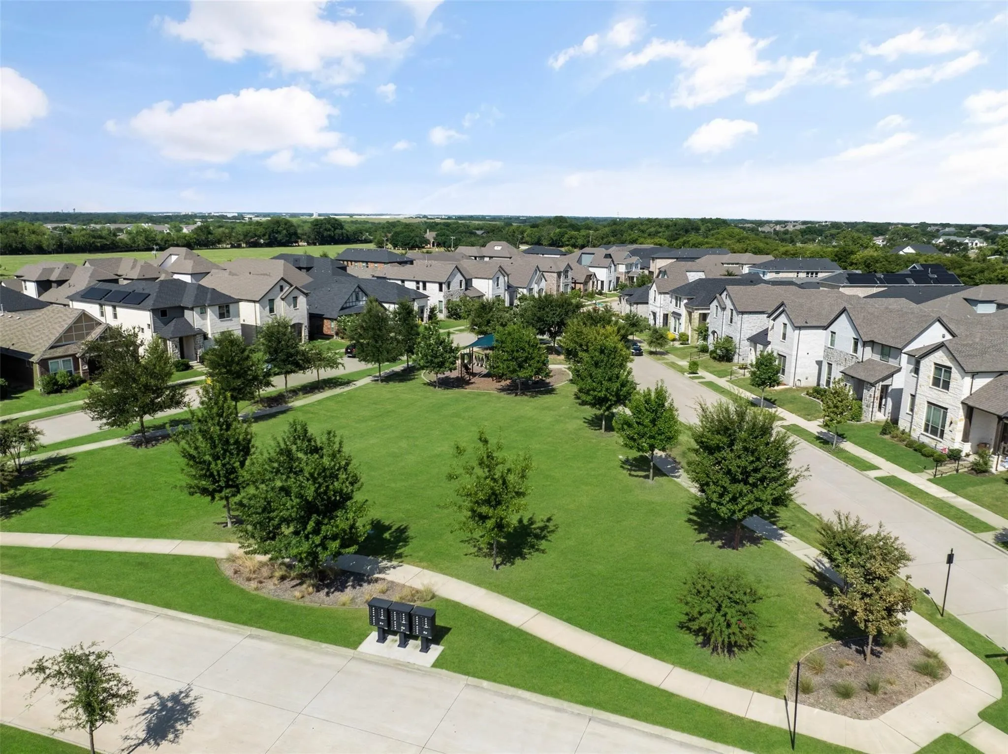 Expansive green spaces featuring mature trees and paved walking paths