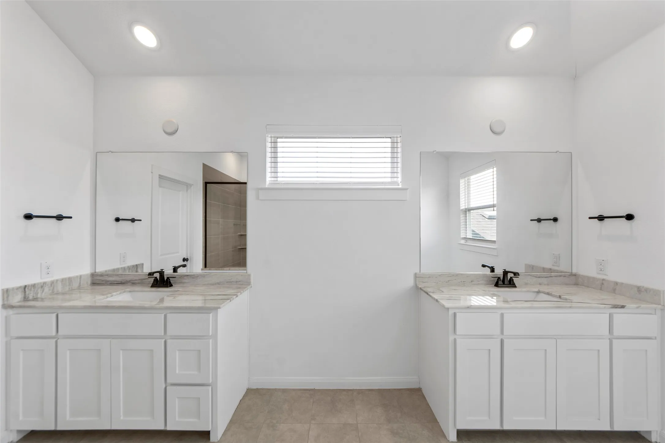 Primary Bathroom Suite Featuring Dual Vanities with Quartz Countertops and Undermount SinksThis spa-inspired bathroom showcases a symmetrical dual-vanity layout with white cabinetry, brushed nickel hardware, and polished quartz countertops