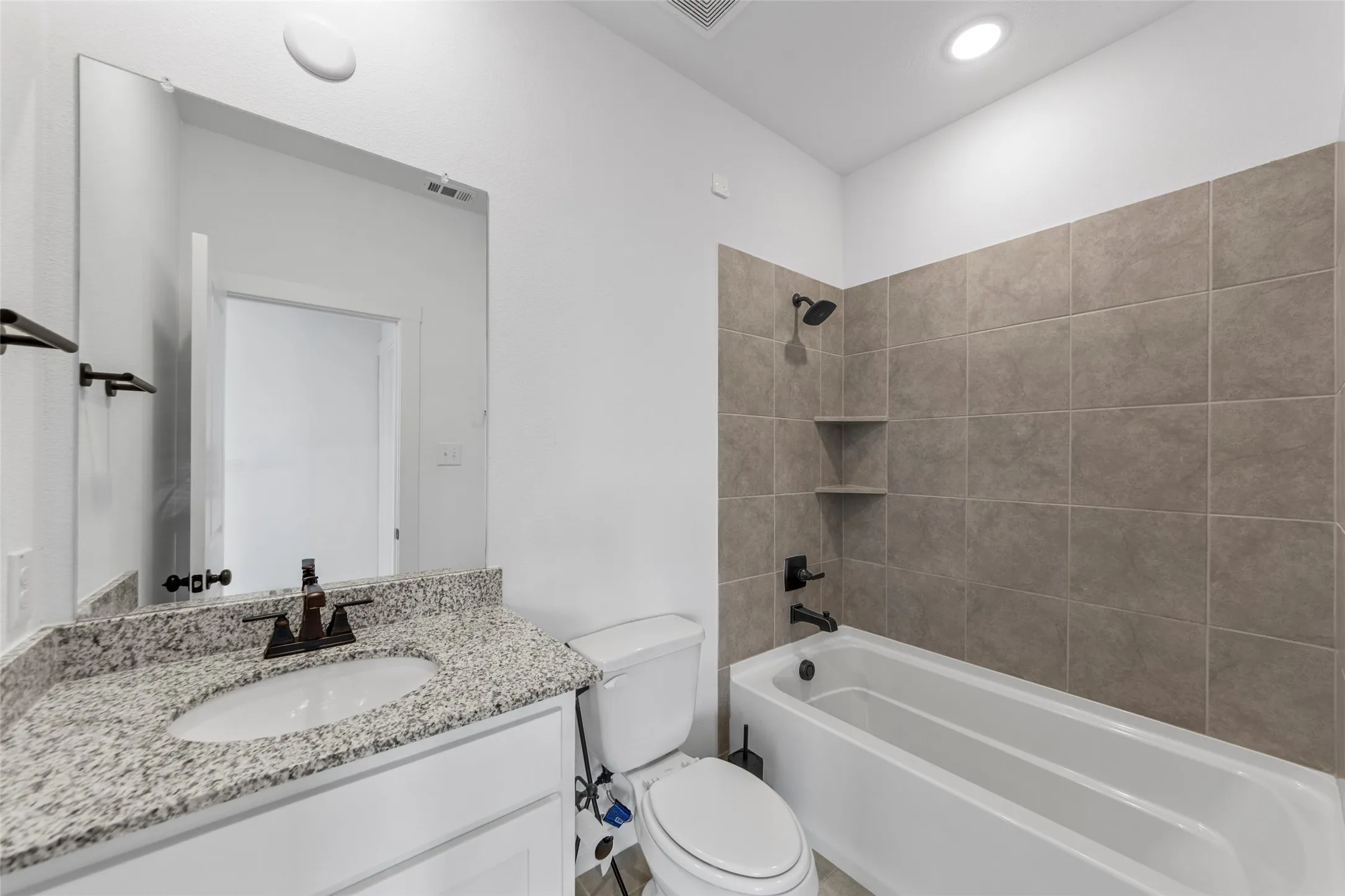 White vanity with a granite countertop and an undermount sink
