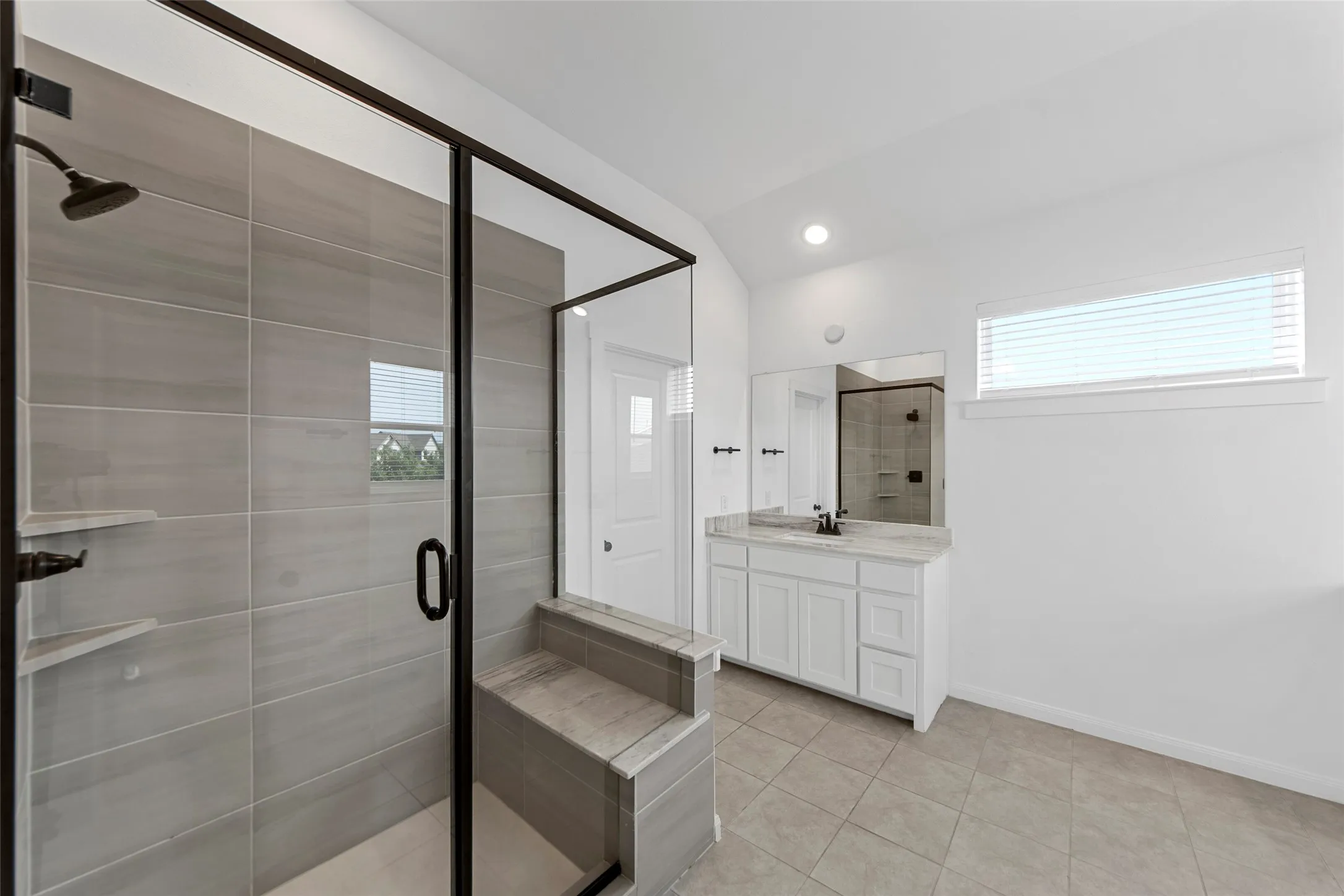 Spa-inspired primary bathroom featuring a frameless glass-enclosed shower with linear tile detailing, a floating white vanity with dual sinks, quartz countertop, and brushed nickel fixtures