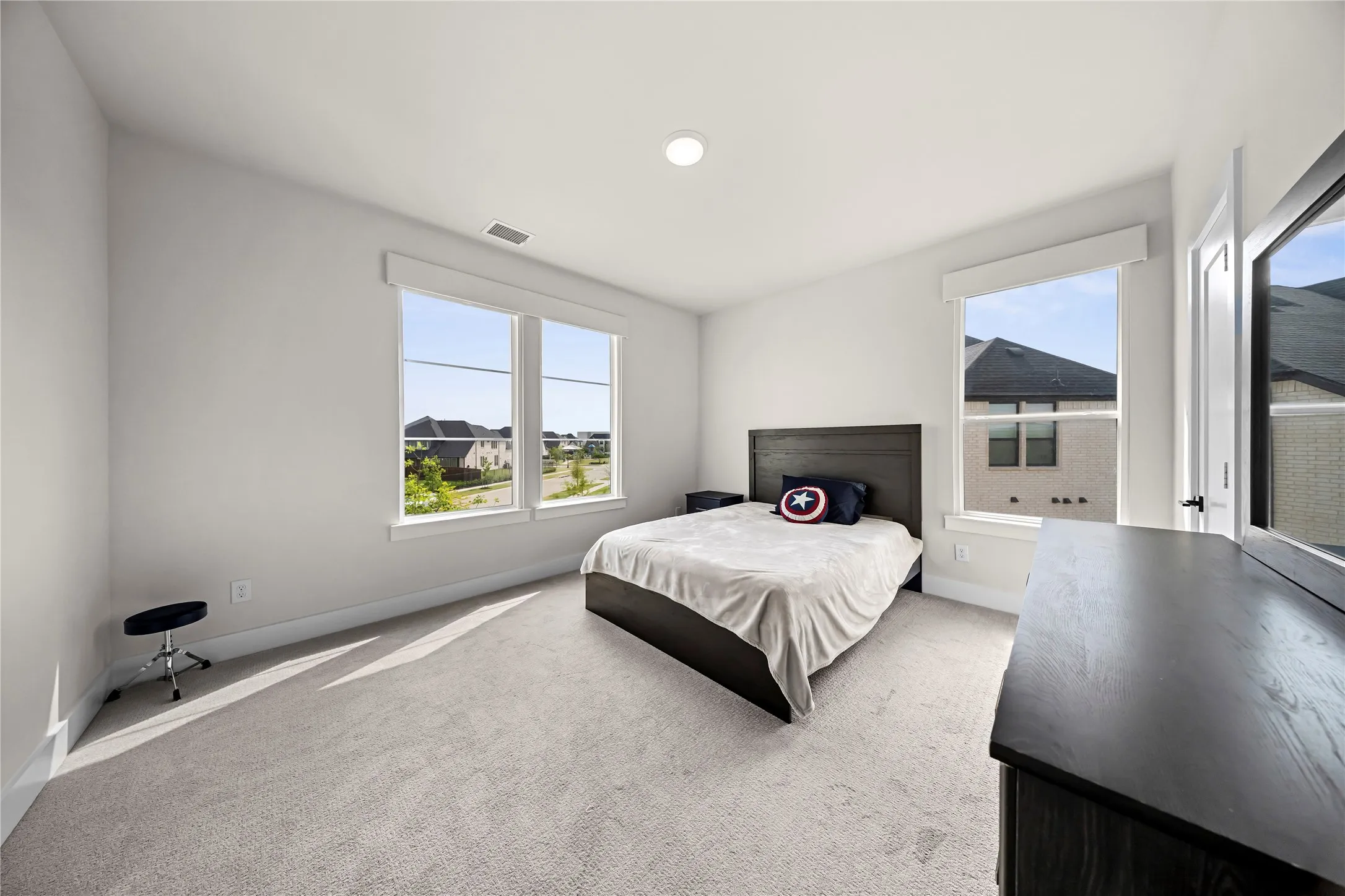 Recessed lighting, large windows, light-toned carpeting, white walls, and white trim