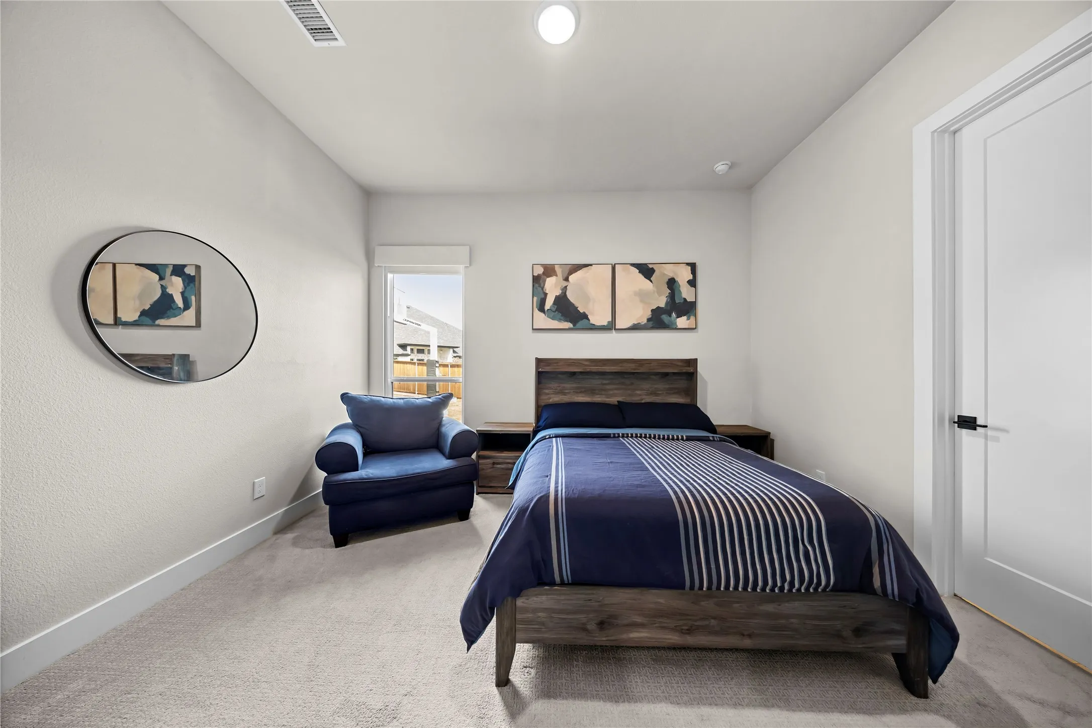 Carpeted bedroom featuring a window, recessed lighting, and a solid core door with matte black hardware