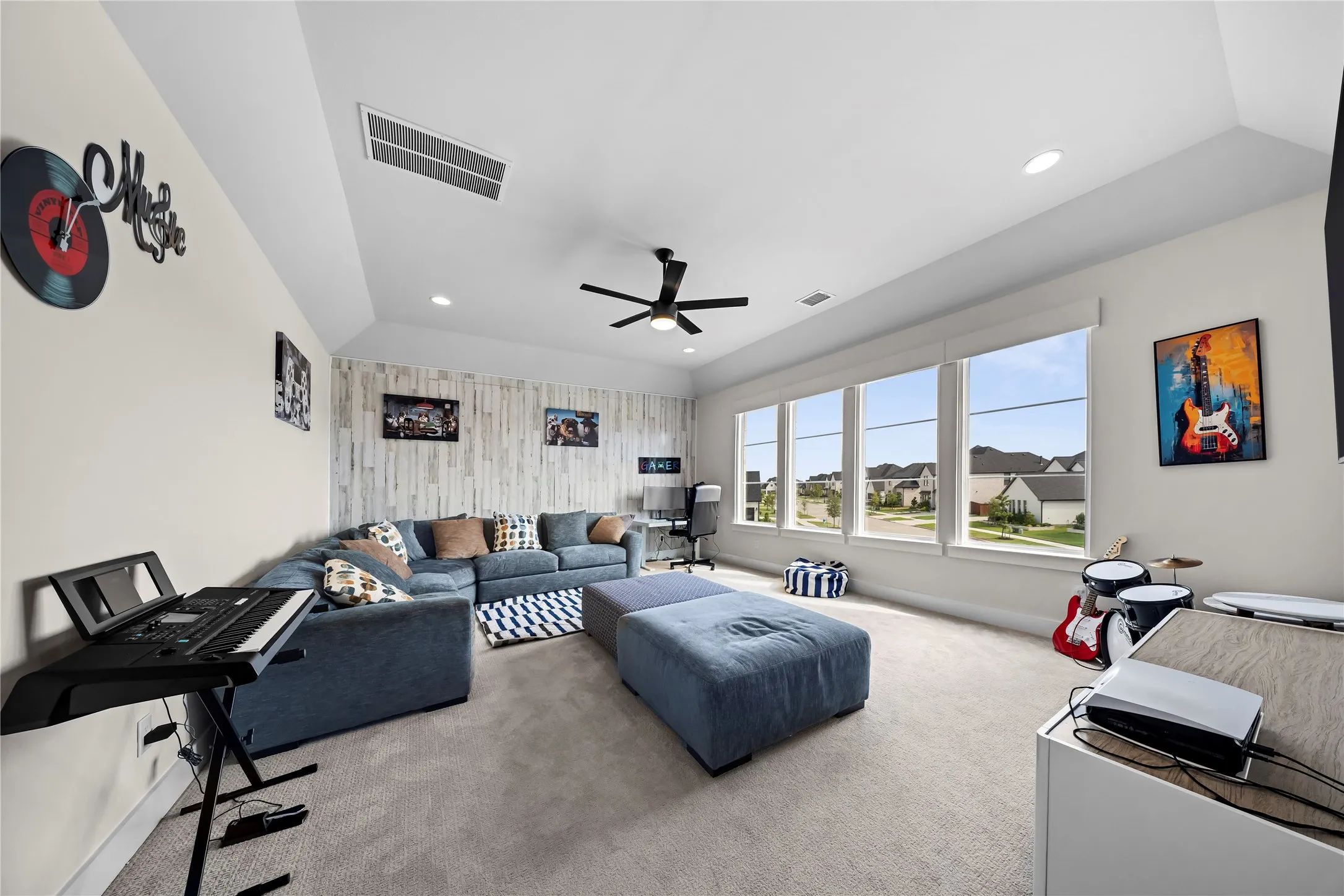 Recessed lighting, sloped ceiling, ceiling fan, carpet flooring, and a window bank