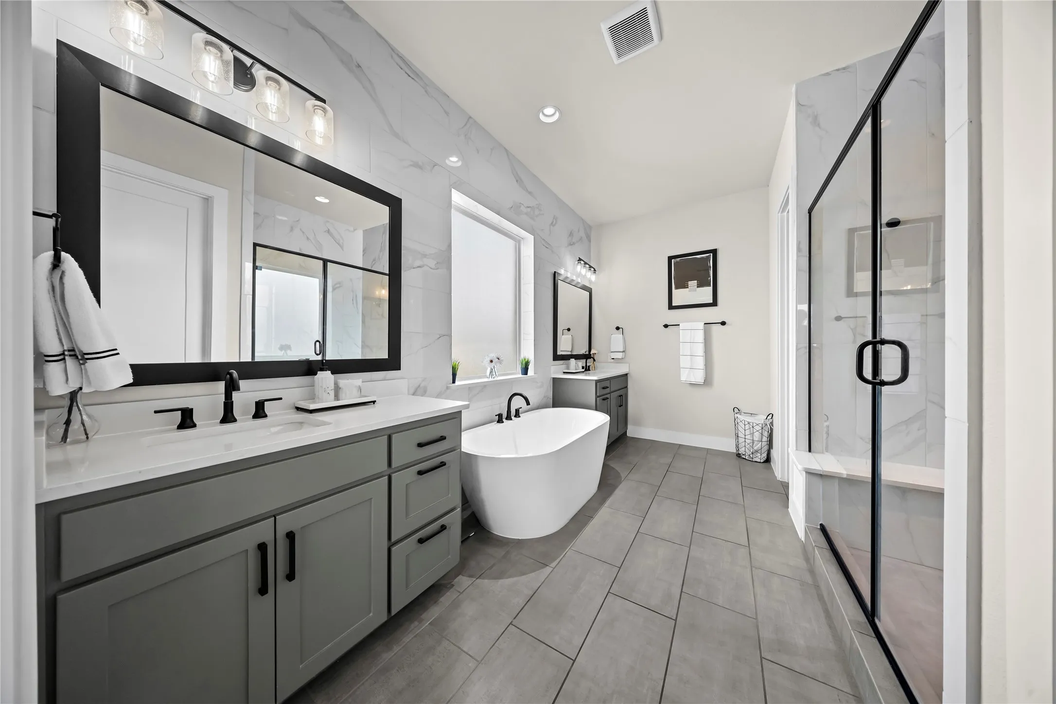 Dual vanity with gray cabinetry and white countertops