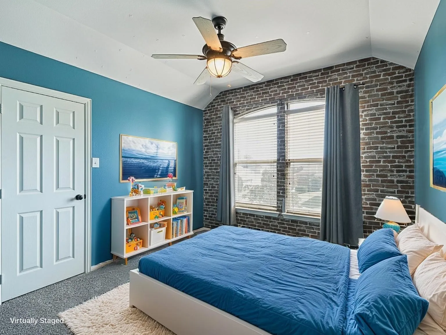 Accent brick wall, arched window with blinds, ceiling fan with light fixture, four-panel interior door, and carpet flooring