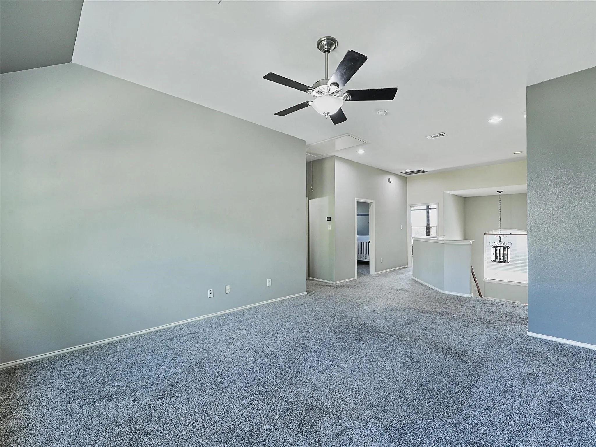 Spacious open-concept living area featuring neutral wall finishes, polished concrete flooring, recessed lighting, and a modern ceiling fan with brushed nickel hardware