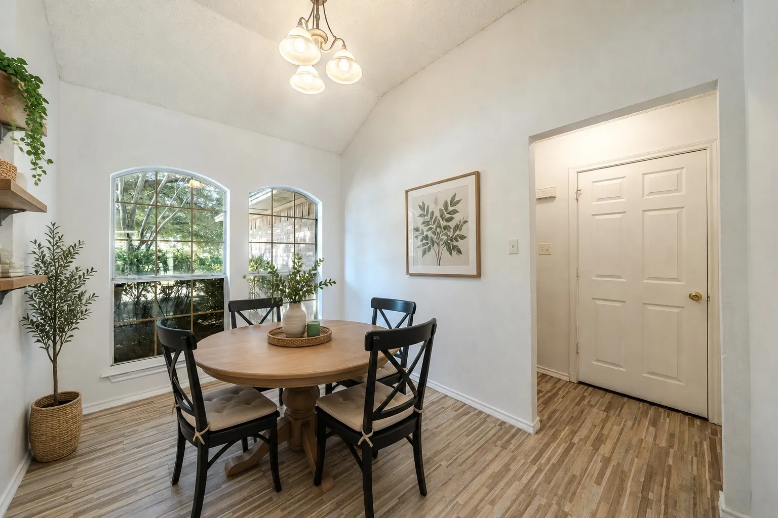 CUTE, virtually-staged bright breakfast area with lovely arched windows and decorative lighting.