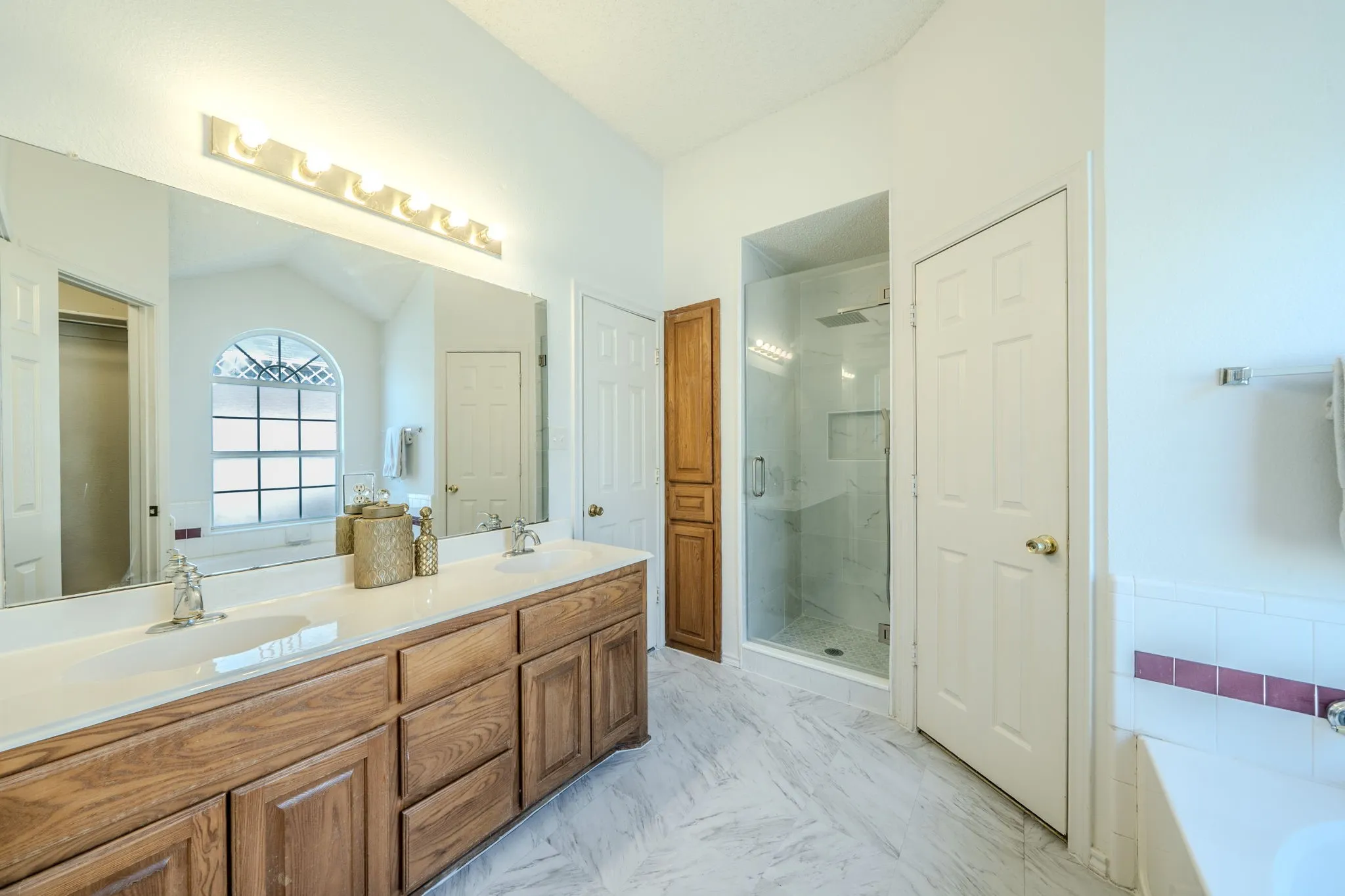 Another view of the primary bathroom with full shower remodel; notice the linen closet!