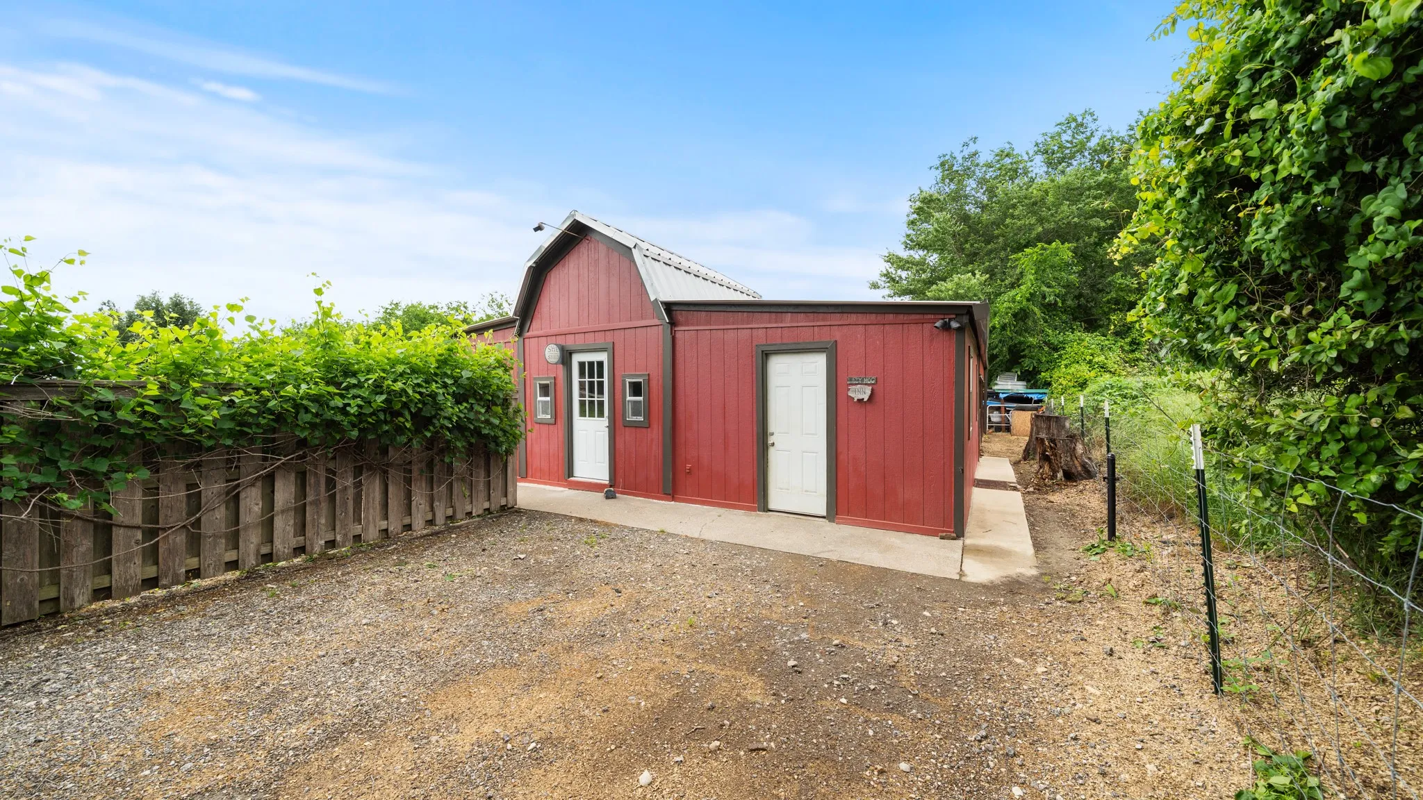Charming red metal utility building with peaked roof and concrete foundation