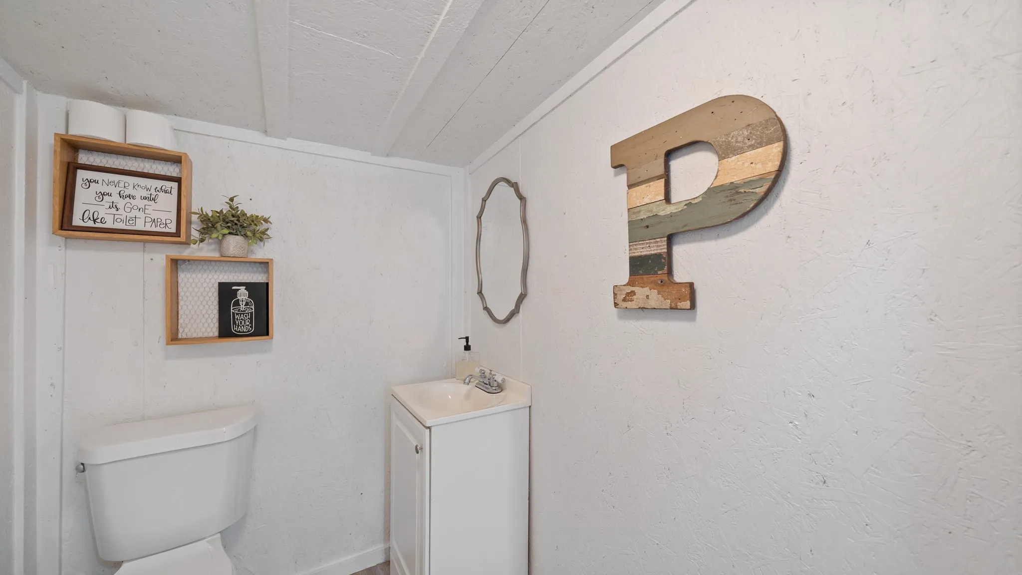 Compact bathroom featuring white subway tile walls, a pedestal sink with chrome fixtures, and a white toilet