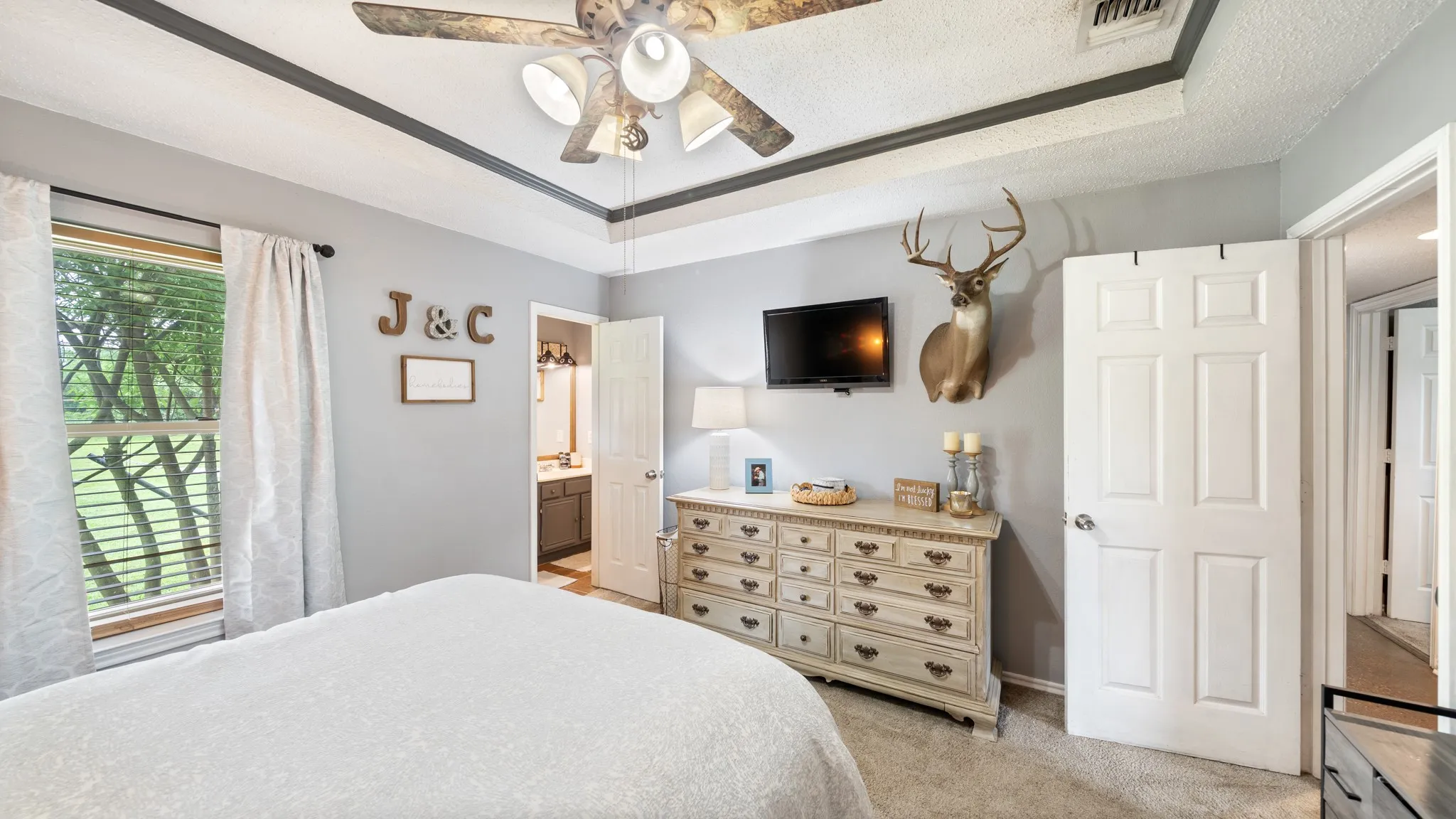 Master bedroom featuring soft neutral walls, wood-finish flooring, and a ceiling fan with integrated lighting