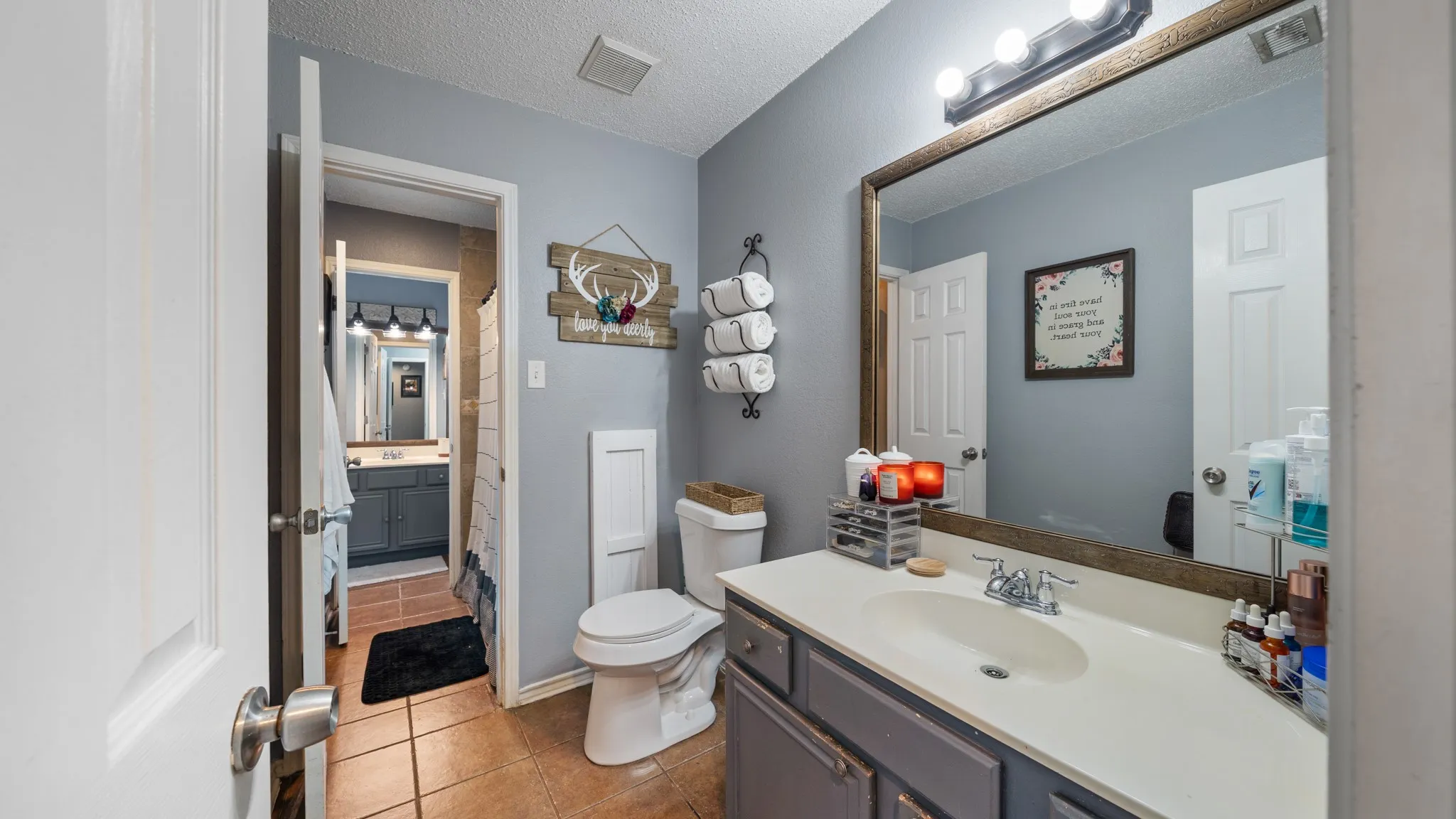 Dual-sink vanity with wood-finish cabinetry, white quartz countertop, and chrome faucetry
