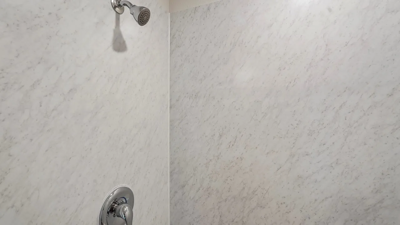 Shower enclosure with textured wall panels and a chrome showerhead