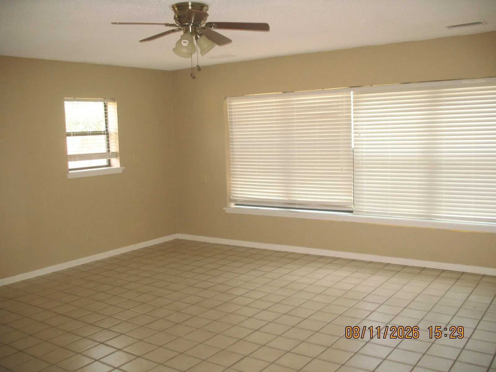 Recessed ceiling fan with light fixture, neutral wall paint, tile flooring, and multiple windows with blinds