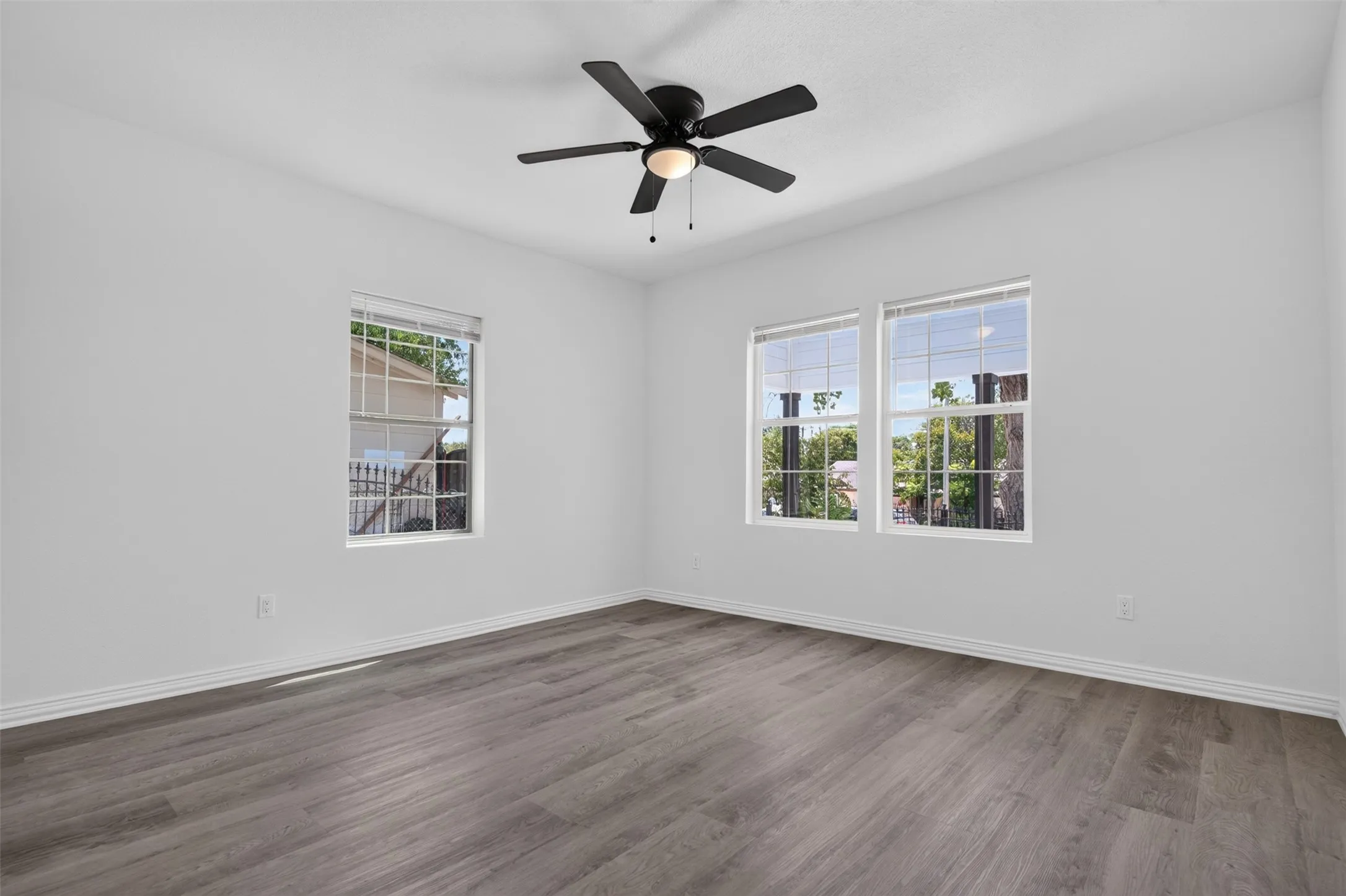 Bright and spacious bedroom featuring wood-finish flooring, recessed lighting, and a ceiling fan with integrated light fixture