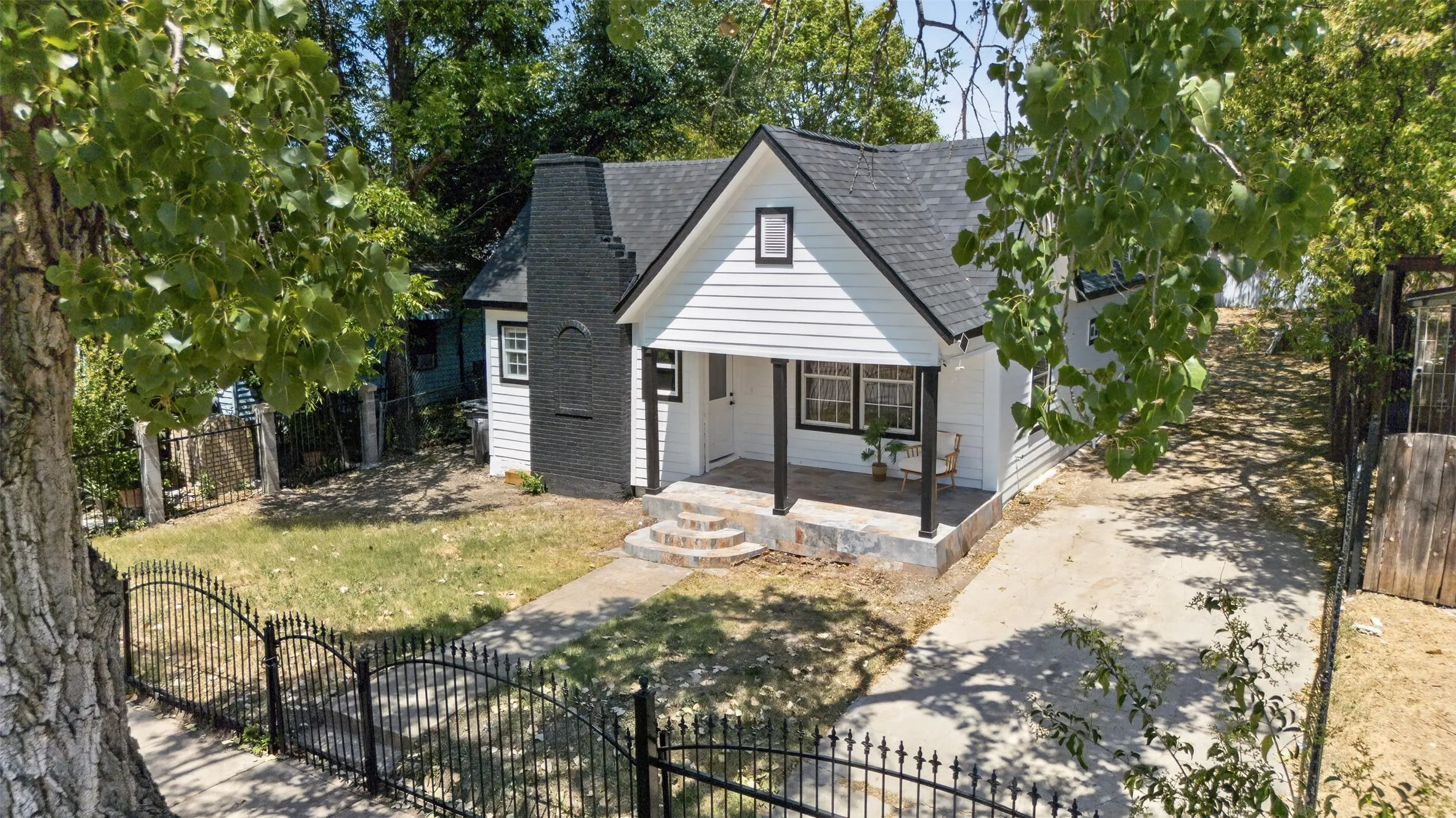 Charming cottage-style home featuring a gabled roof, white board-and-batten siding, and a covered front porch