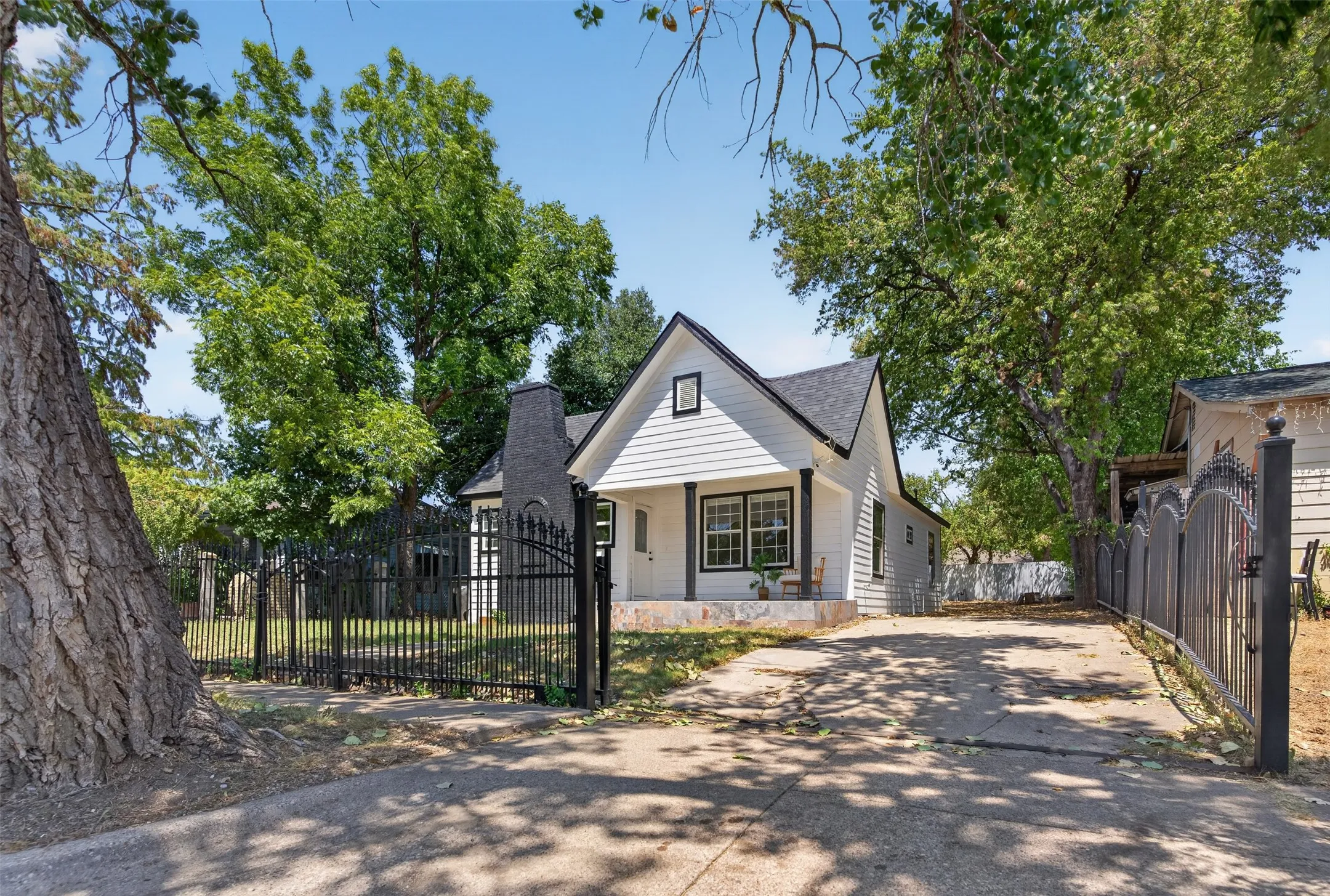 Charming cottage-style residence featuring a gabled roofline and light-colored exterior siding