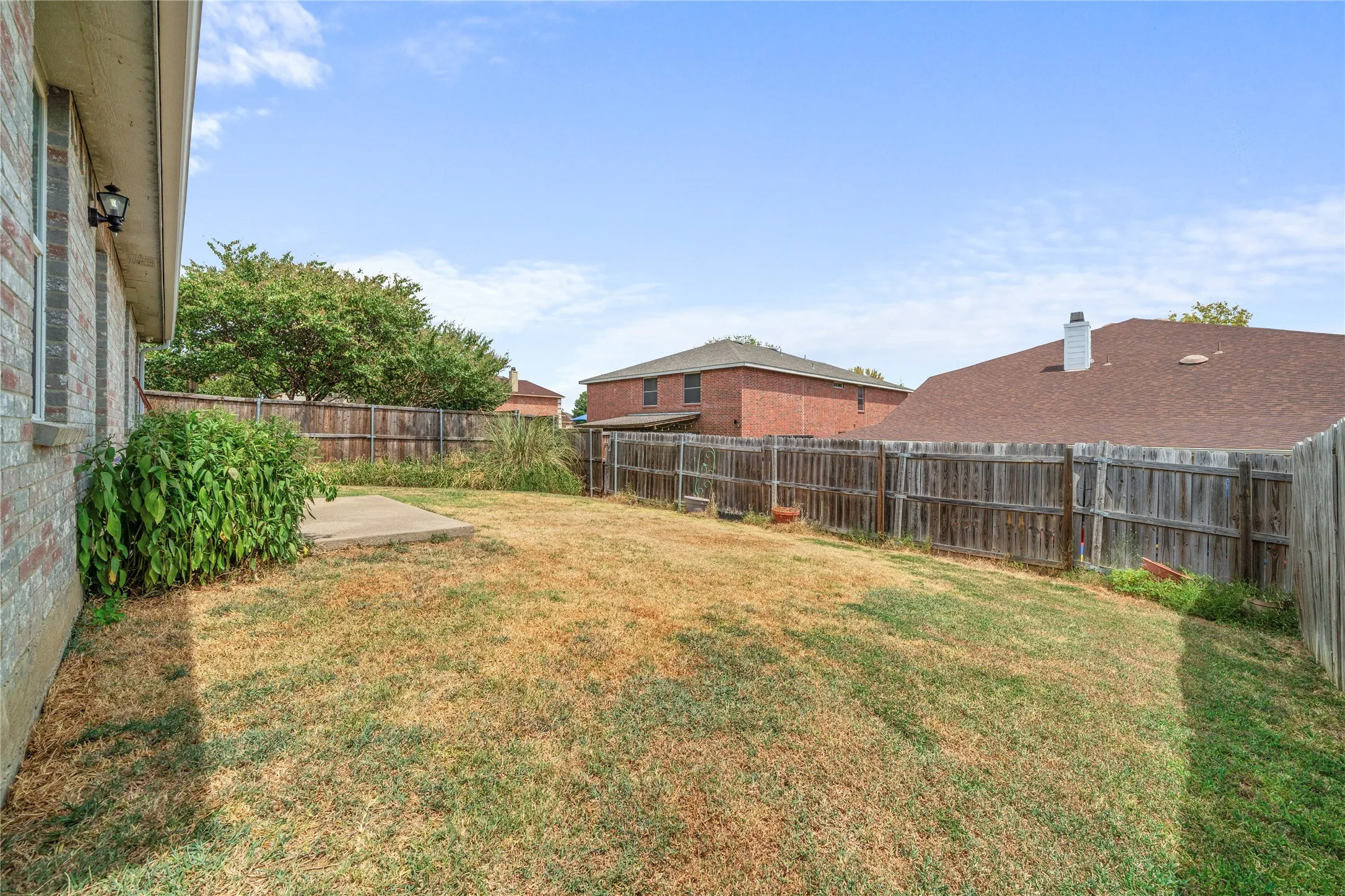 Expansive fenced backyard with a concrete patio
