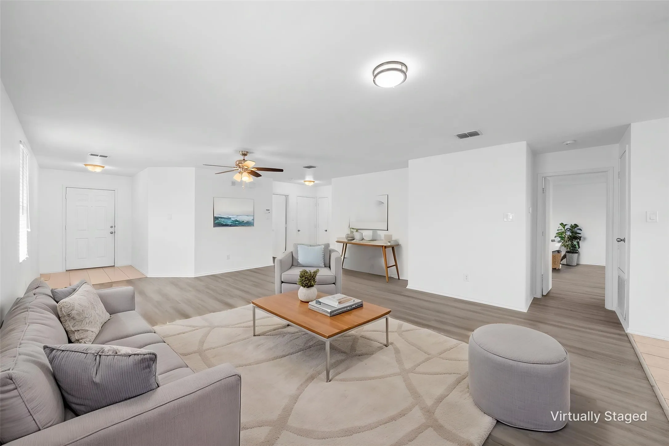 Recessed lighting, wood-finish flooring, ceiling fan, white walls, and a light-colored entry door