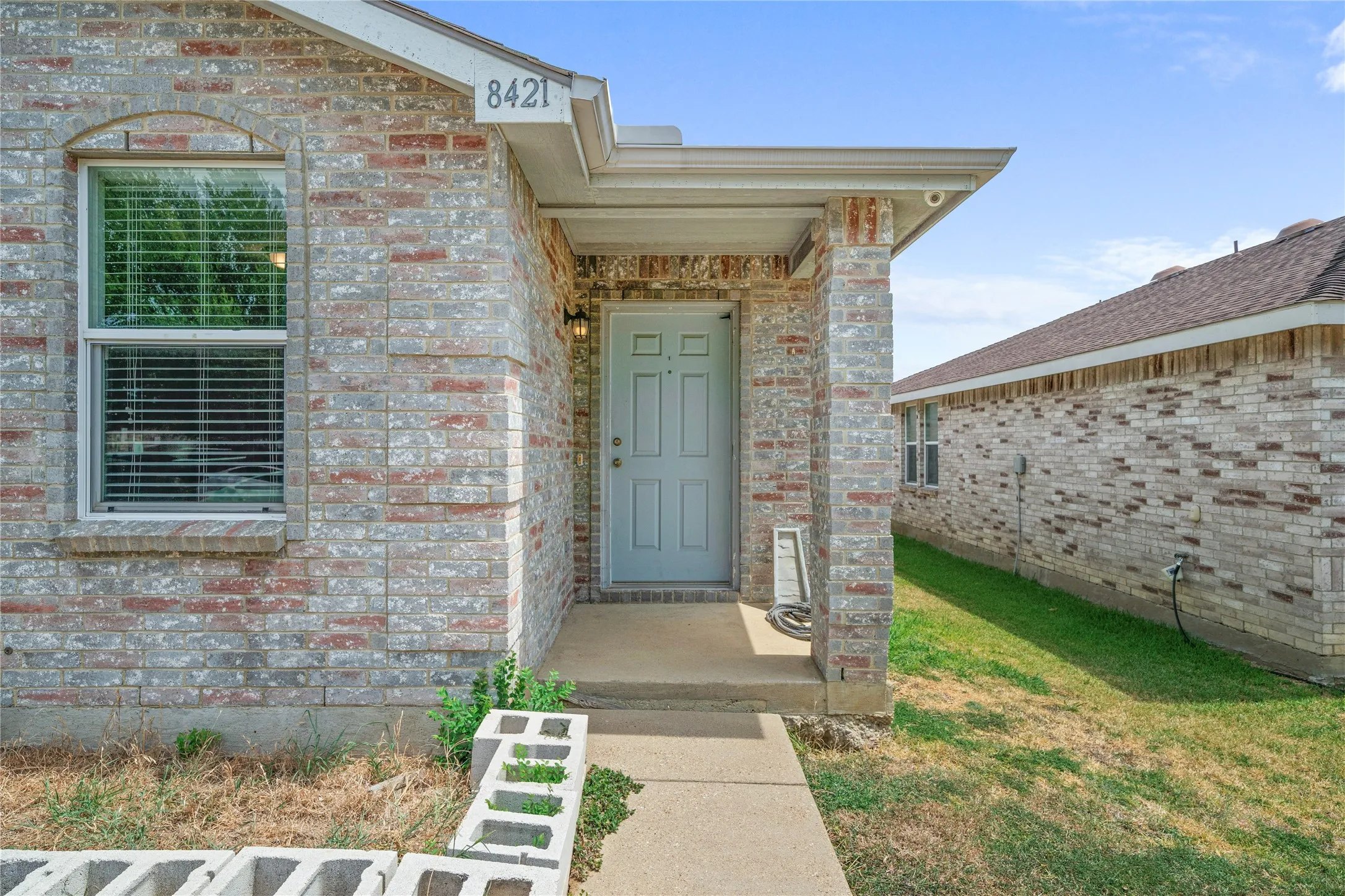 Brick exterior with covered entry and concrete walkway