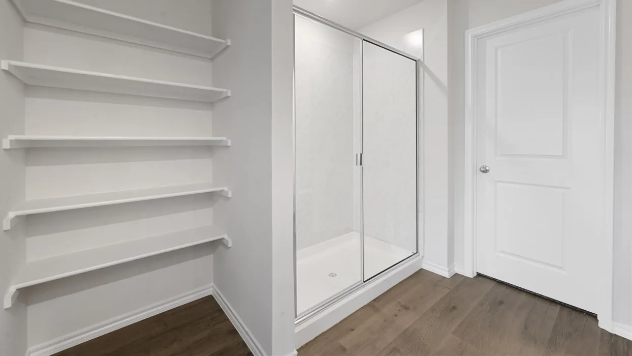 Primary Bathroom Suite featuring a frameless glass-enclosed shower with chrome hardware, floating vanity, wood-finish flooring, and abundant natural lighting from transom windows