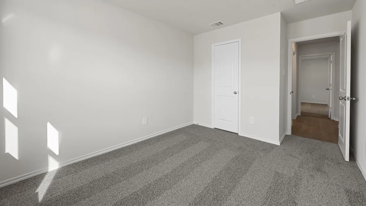 Bright bedroom with abundant natural light from dual windows, neutral wall finishes, and neutral-toned carpet flooring