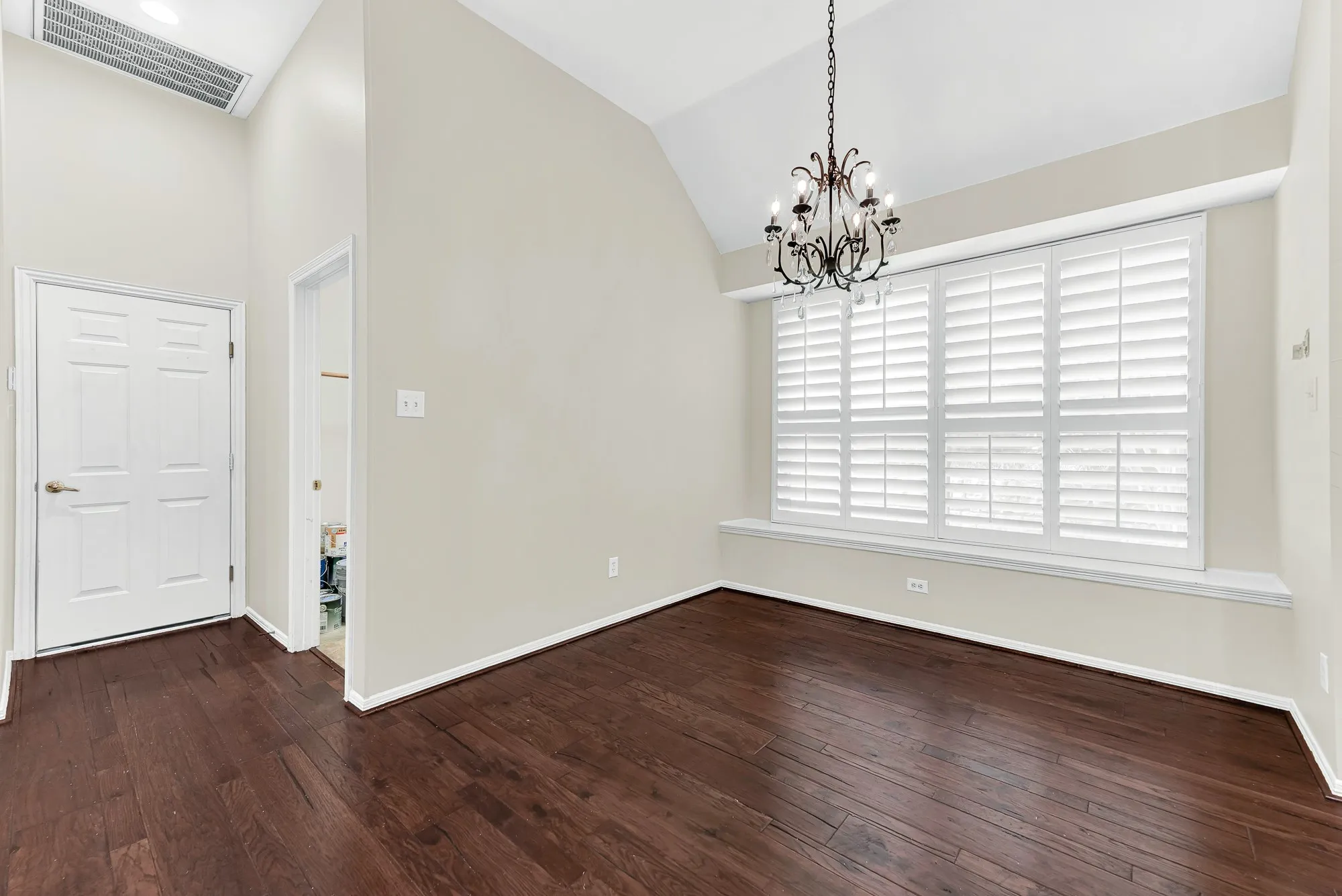 High sloped ceilings and a classic chandelier draw your eye to the sunlit window seat and nearby pantry area. It makes a cozy, sun-filled dining spot for starting your day on a bright and restful note