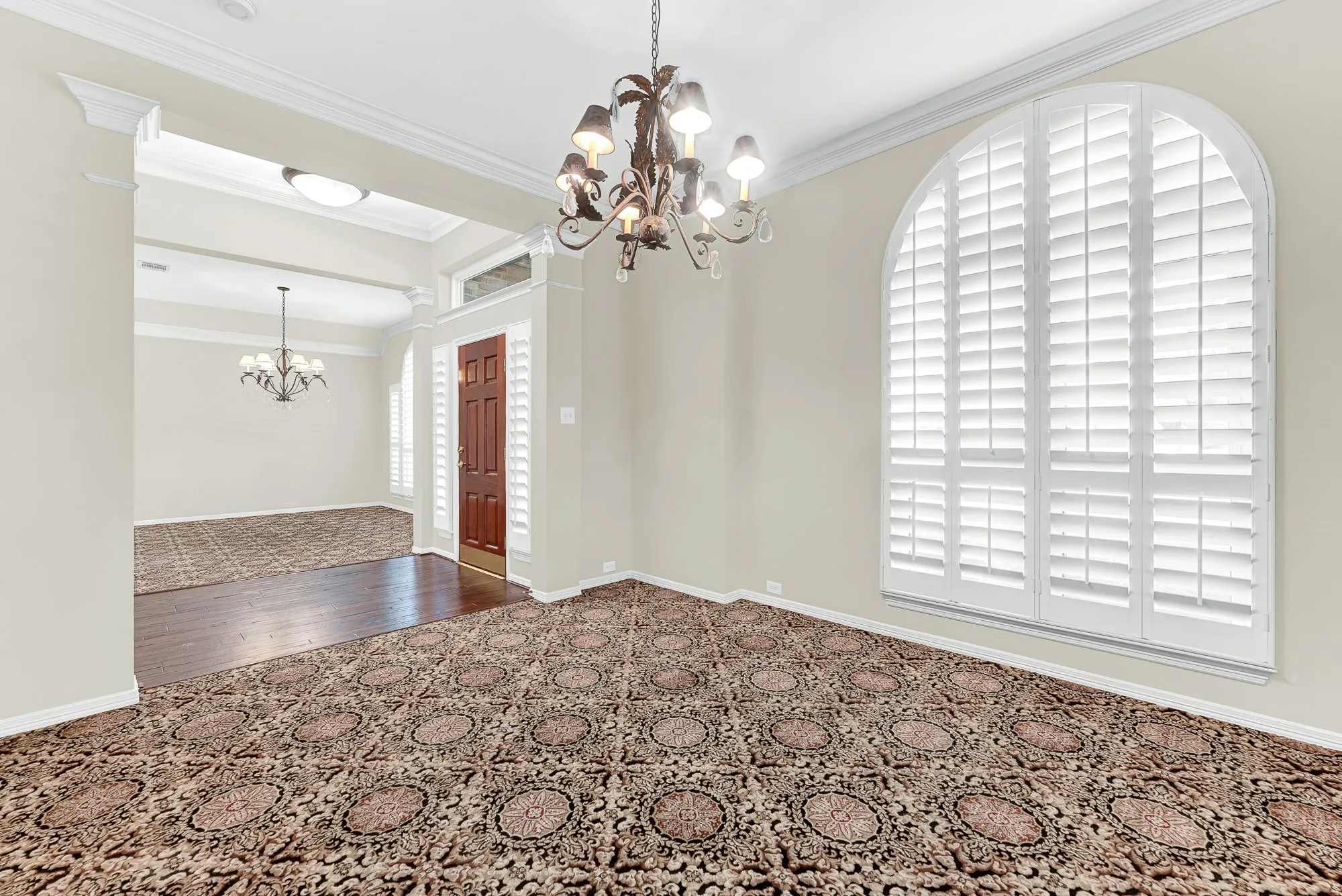 Looking across the formal living room toward the entry and dining space, this angle highlights the open architectural transitions and light-filled windows. The seamless layout makes hosting gatherings effortless, allowing friends to mingle naturally throughout the home.
