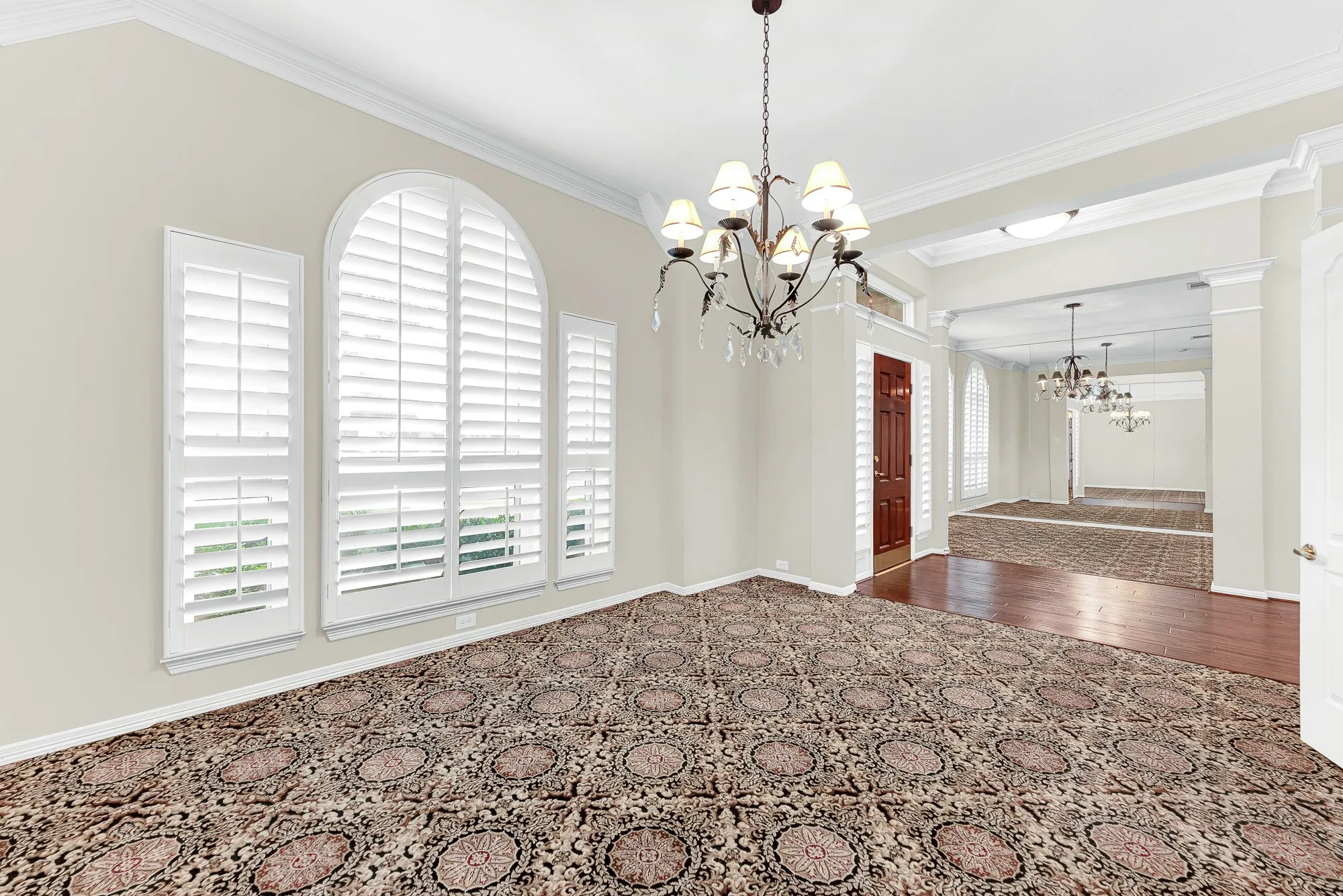 This angle showcases the gracious open layout connecting the dining room to the grand foyer and front entryway. Guests will feel instantly welcomed as they transition seamlessly from the front door into warm, lively dinner celebrations.