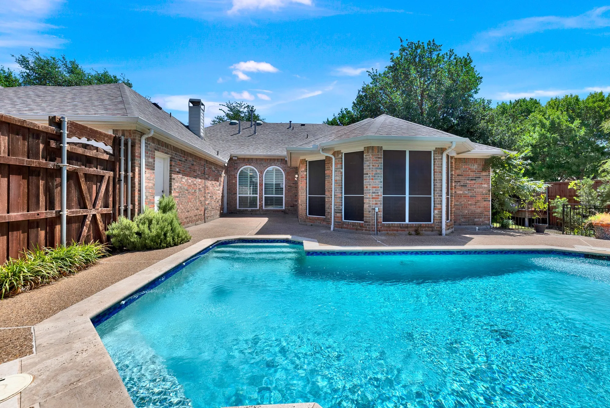 A wide view reveals the full expanse of the pool area along with the patio space directly accessible from the home’s main living areas. It creates an inviting setting for effortless outdoor living, entertaining guests, and taking in sunny Texas days.